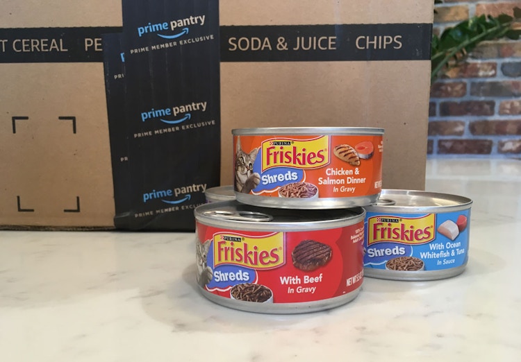 friskies shreds wet canned cat food next to amazon boxes