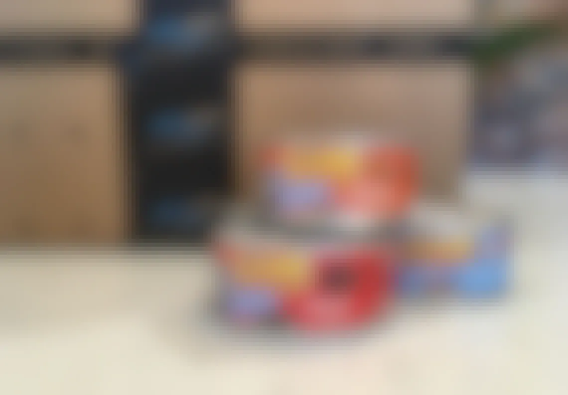 friskies shreds wet canned cat food next to amazon boxes