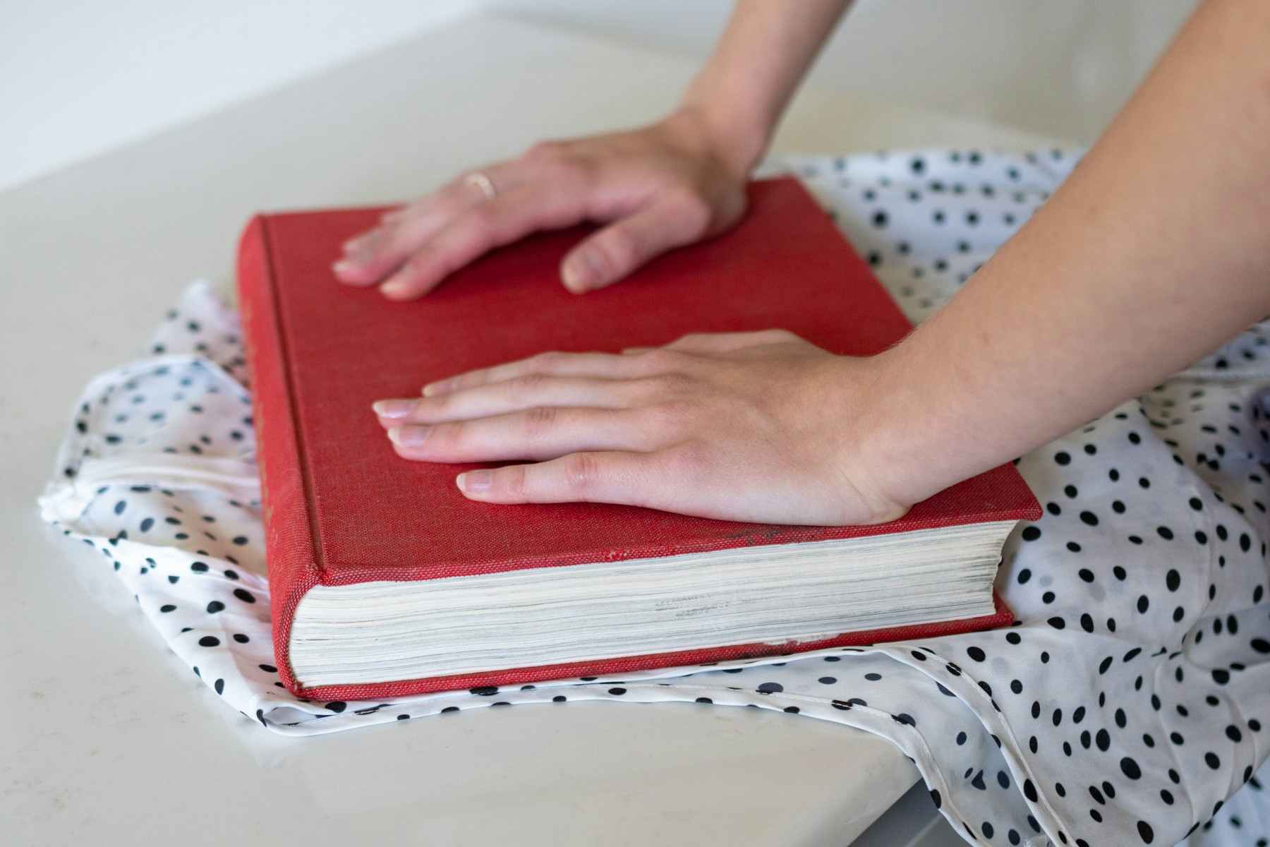 Woman pushing on a heavy book that's been placed over a wrinkled shirt