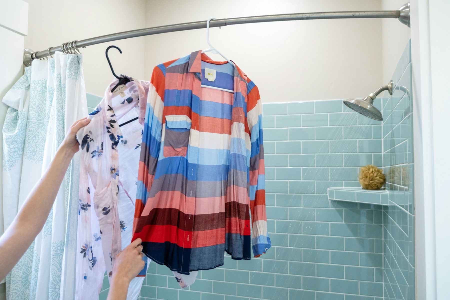 Wrinkled shirts being hung near a running shower