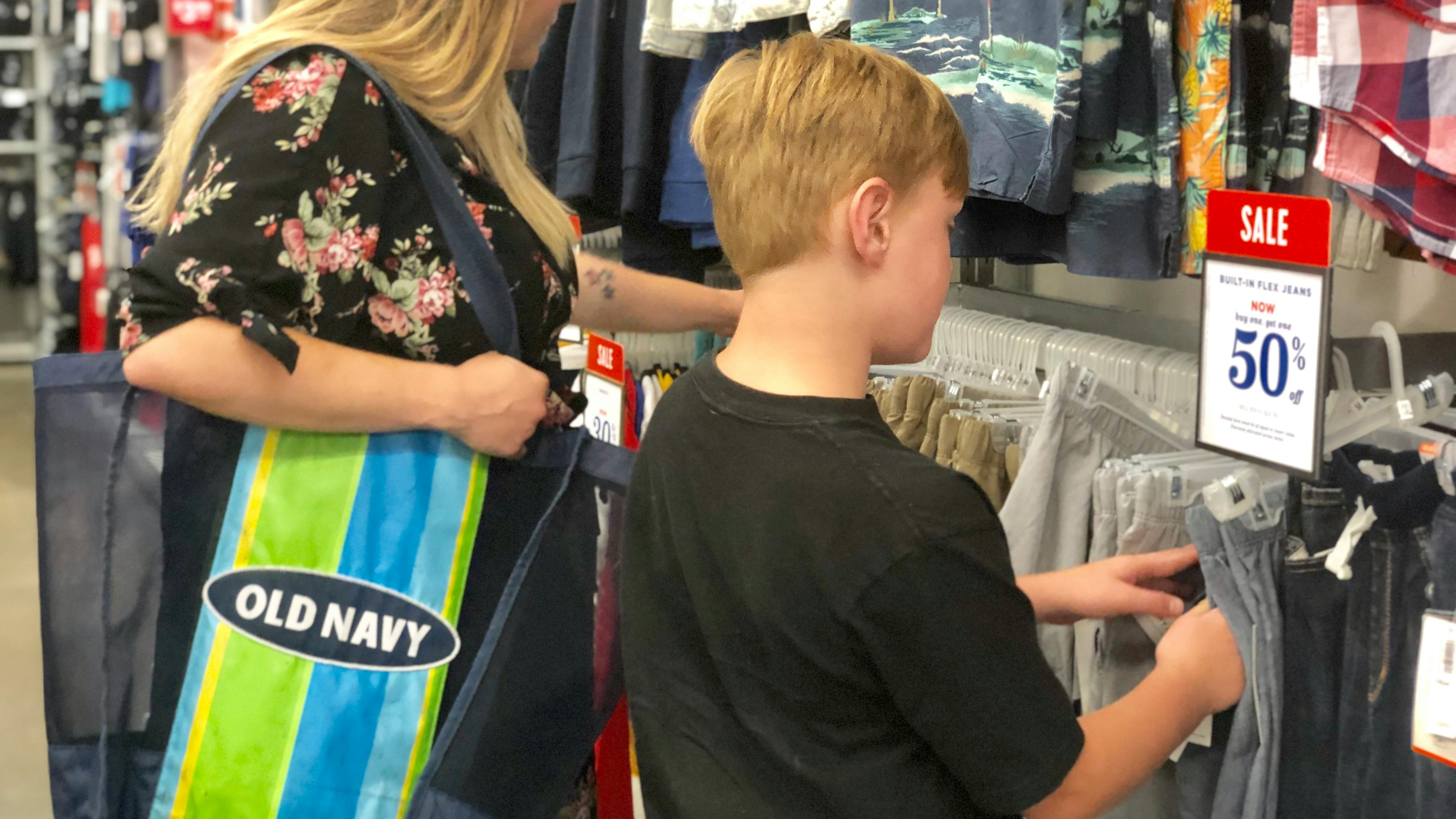 a boy and a woman are looking through clothes at Old Navy