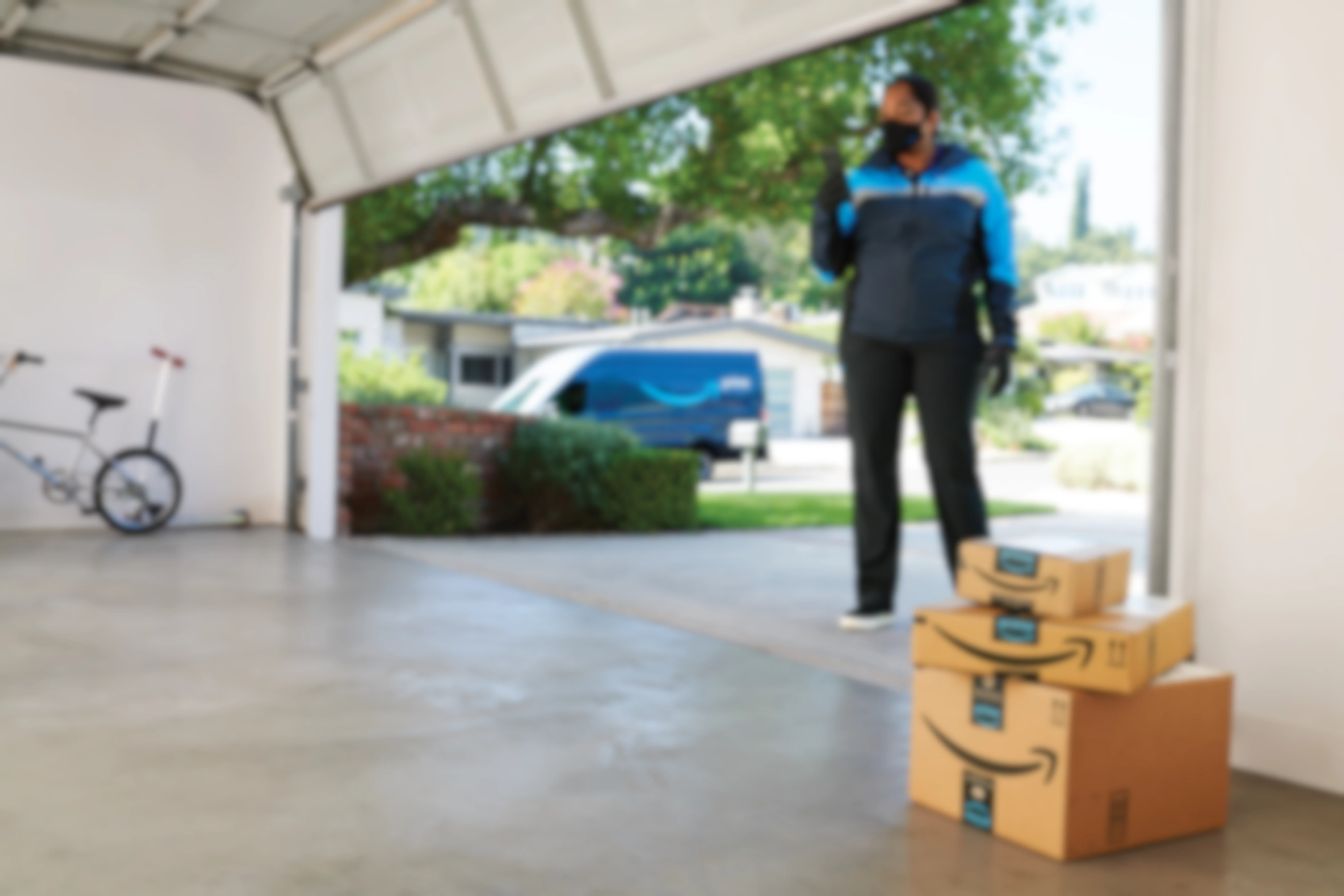 An Amazon delivery driver using the Key for garage delivery option to put Amazon packages inside a garage.