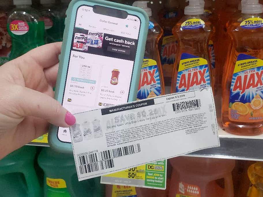 A person holding a smartphone with the ibotta app and a coupon in their hand.
