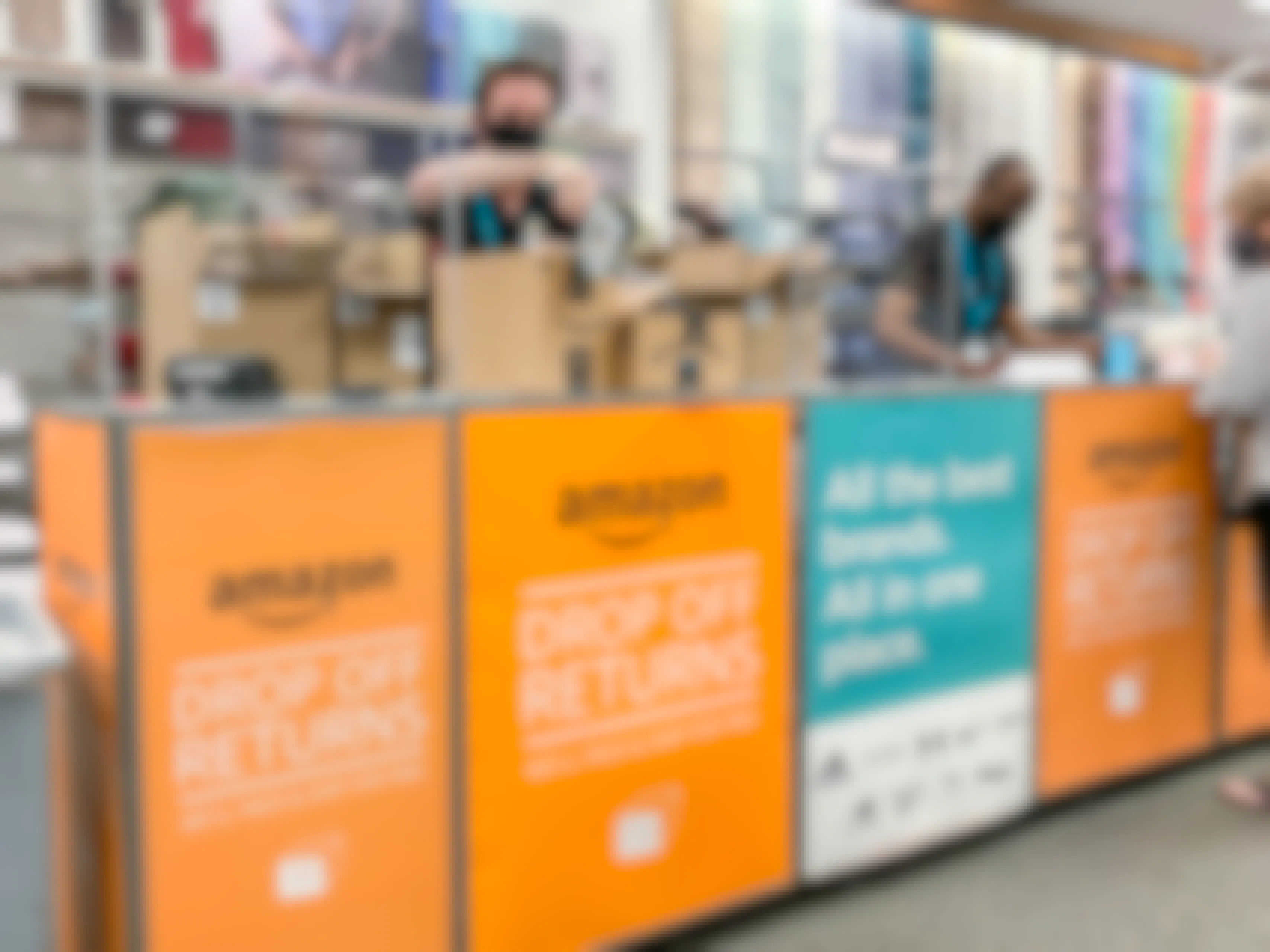 A Kohl's employee taping an Amazon return box at the Amazon Drop Off Returns counter inside Kohl's.