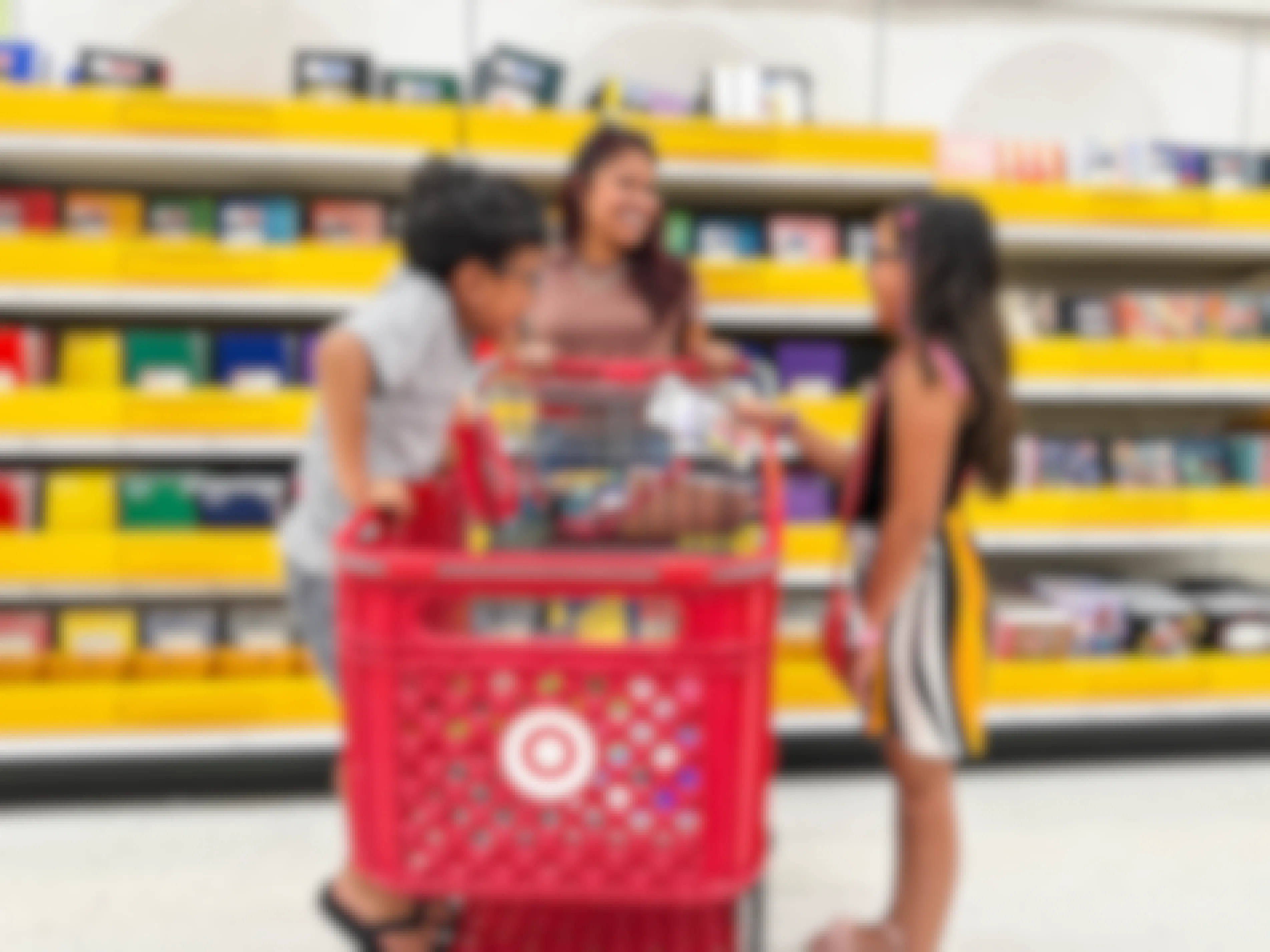 a woman and two kids shopping for school supplies in target 