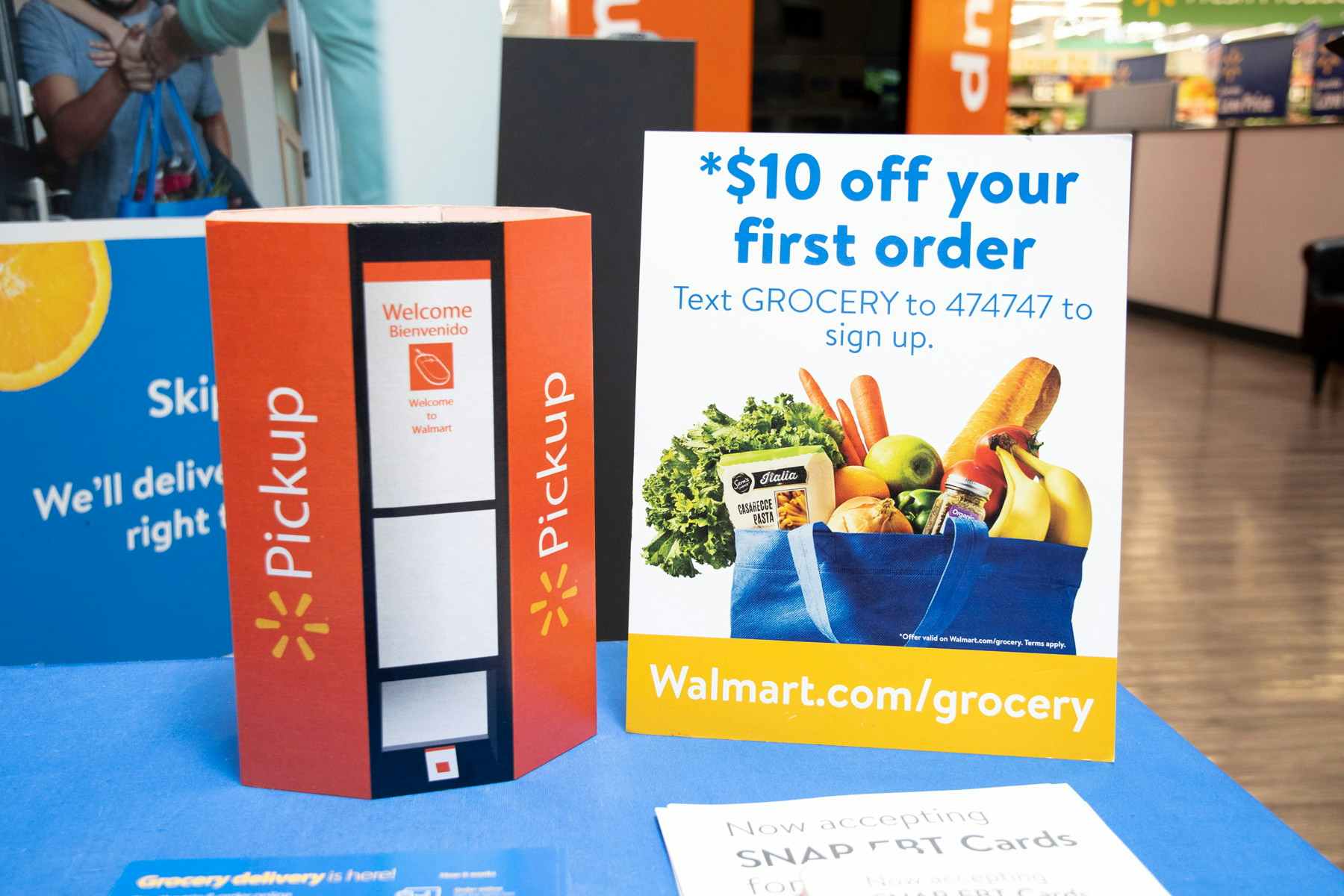 Counter at Walmart that has a sign for pickup and a sign that says $10 off your first order