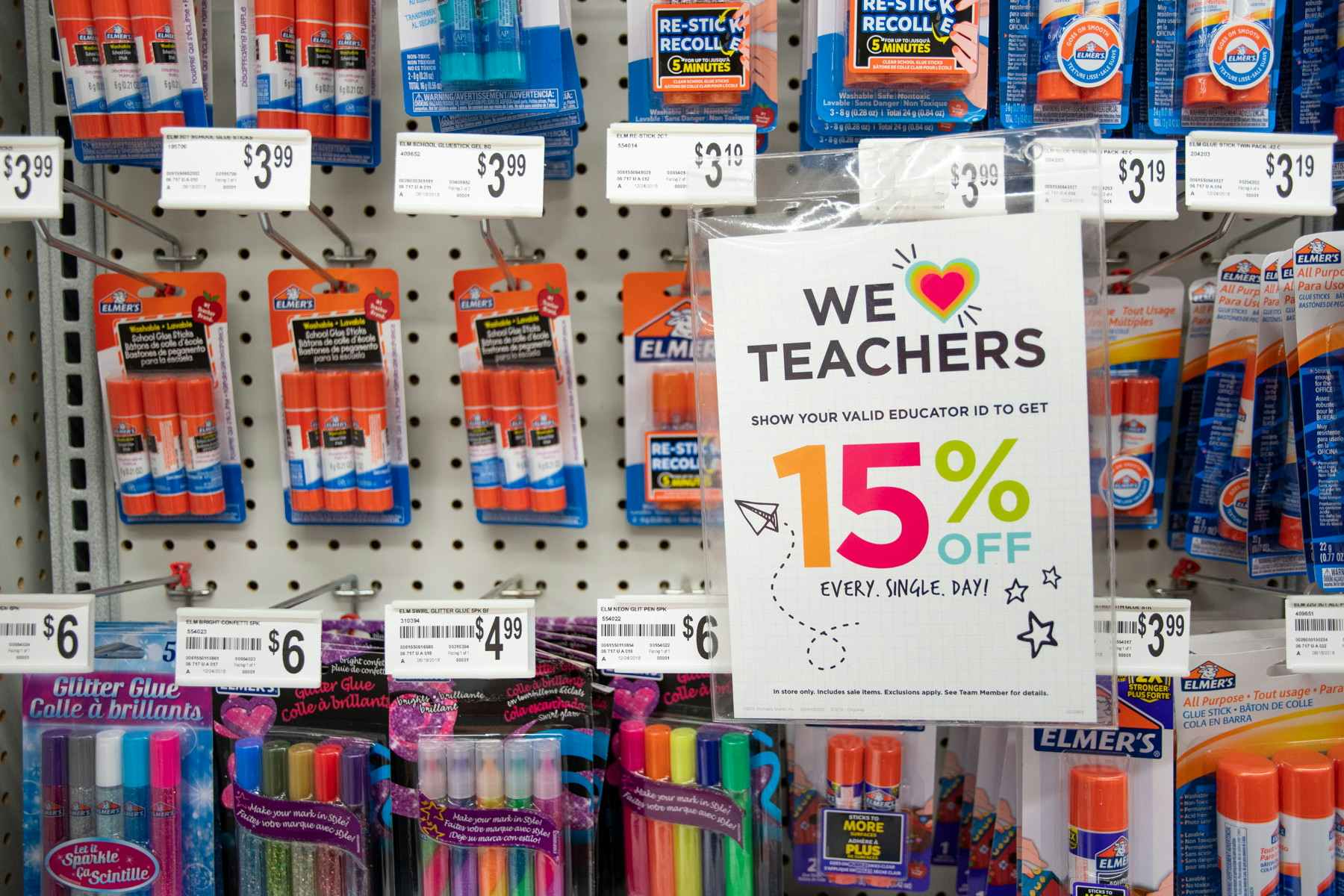 A sign on a wall display at Michaels that says "We love teachers" offering 15% off every day with a valid educator ID.