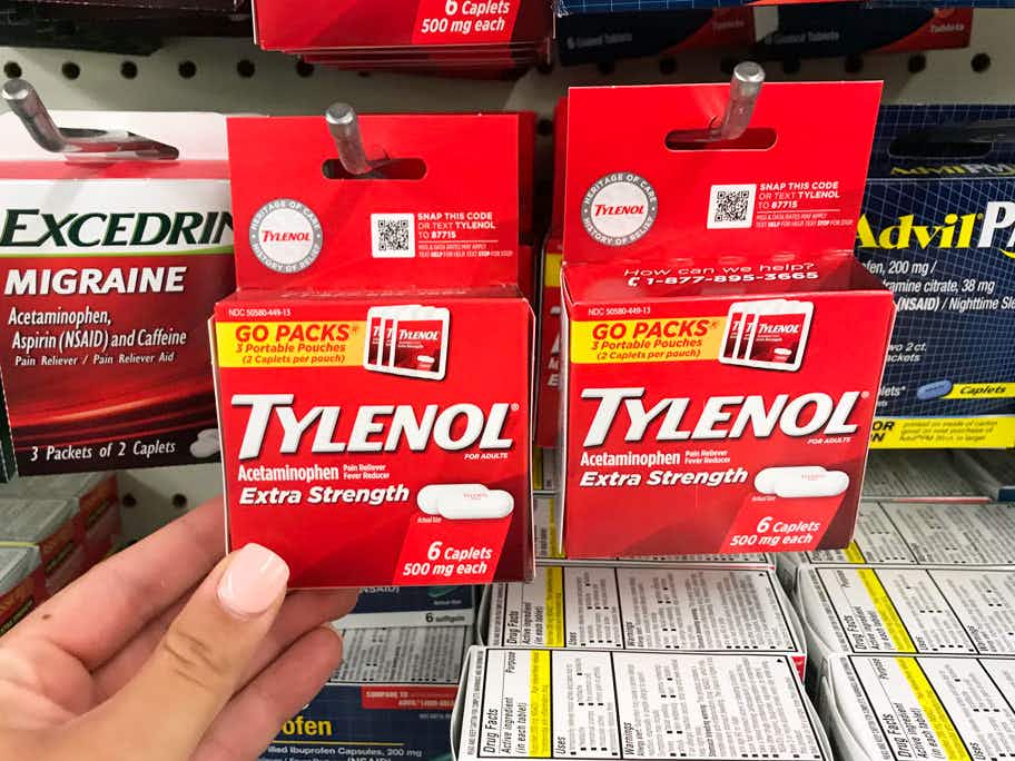 Someone taking some Tylenol from a shelf at Dollar Tree