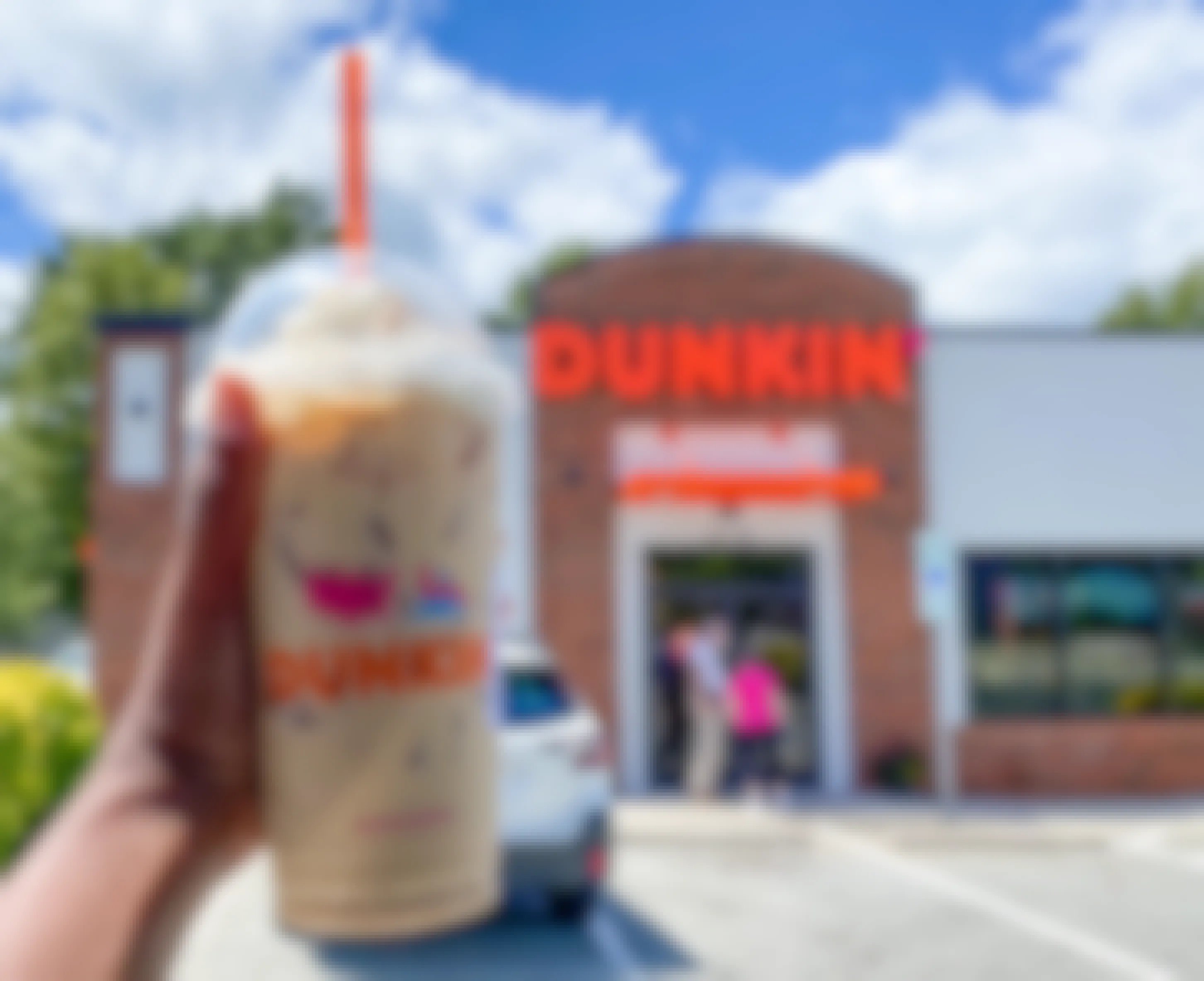 pumpkin spice latte in front of dunkin donuts sign