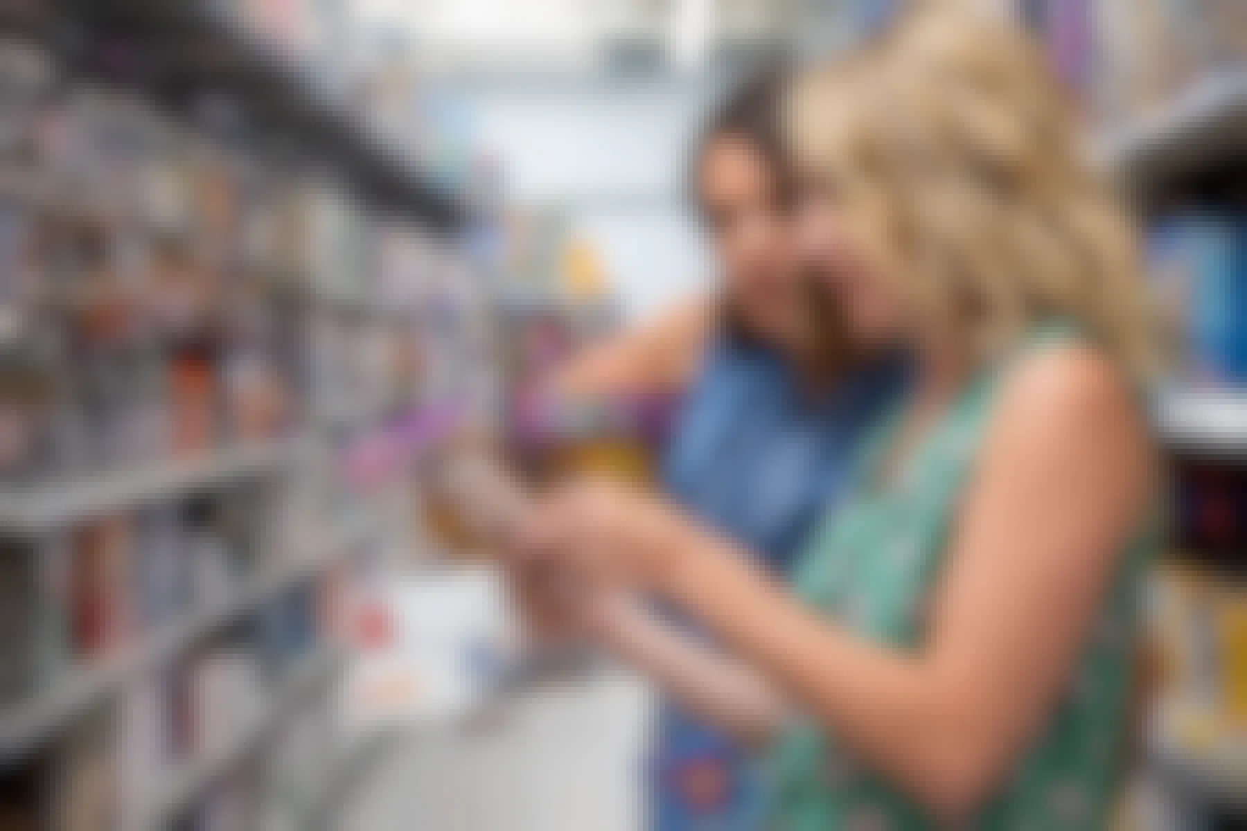 Two women standing in the toy aisle at Walmart, looking at a cell phone.