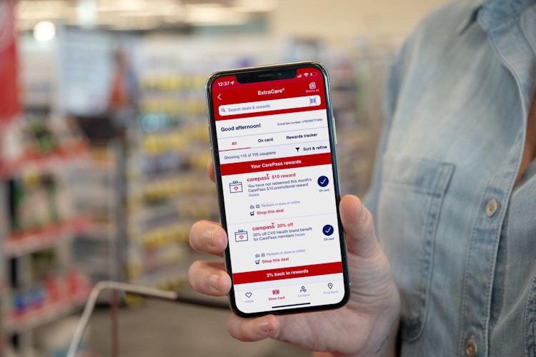 Woman holding a phone with CVS coupons pulled up