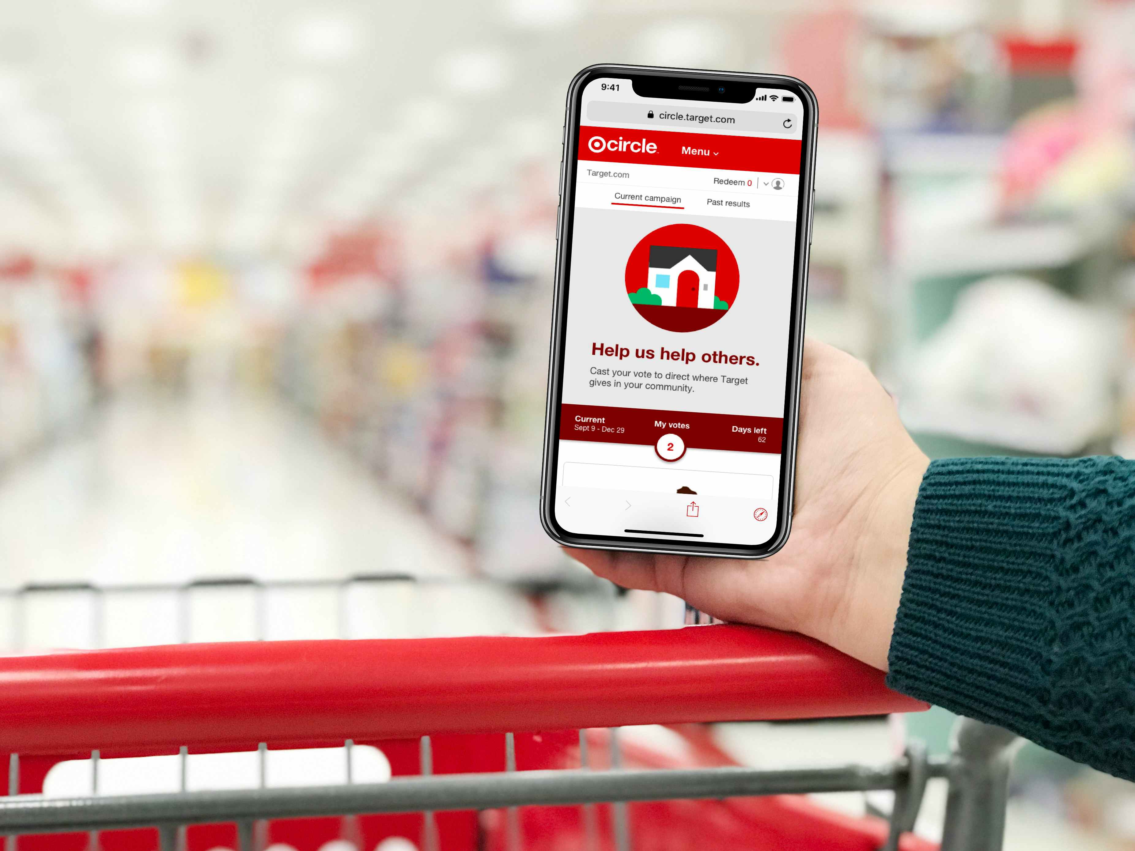 hand resting on a red shopping cart holding phone showing target circle app