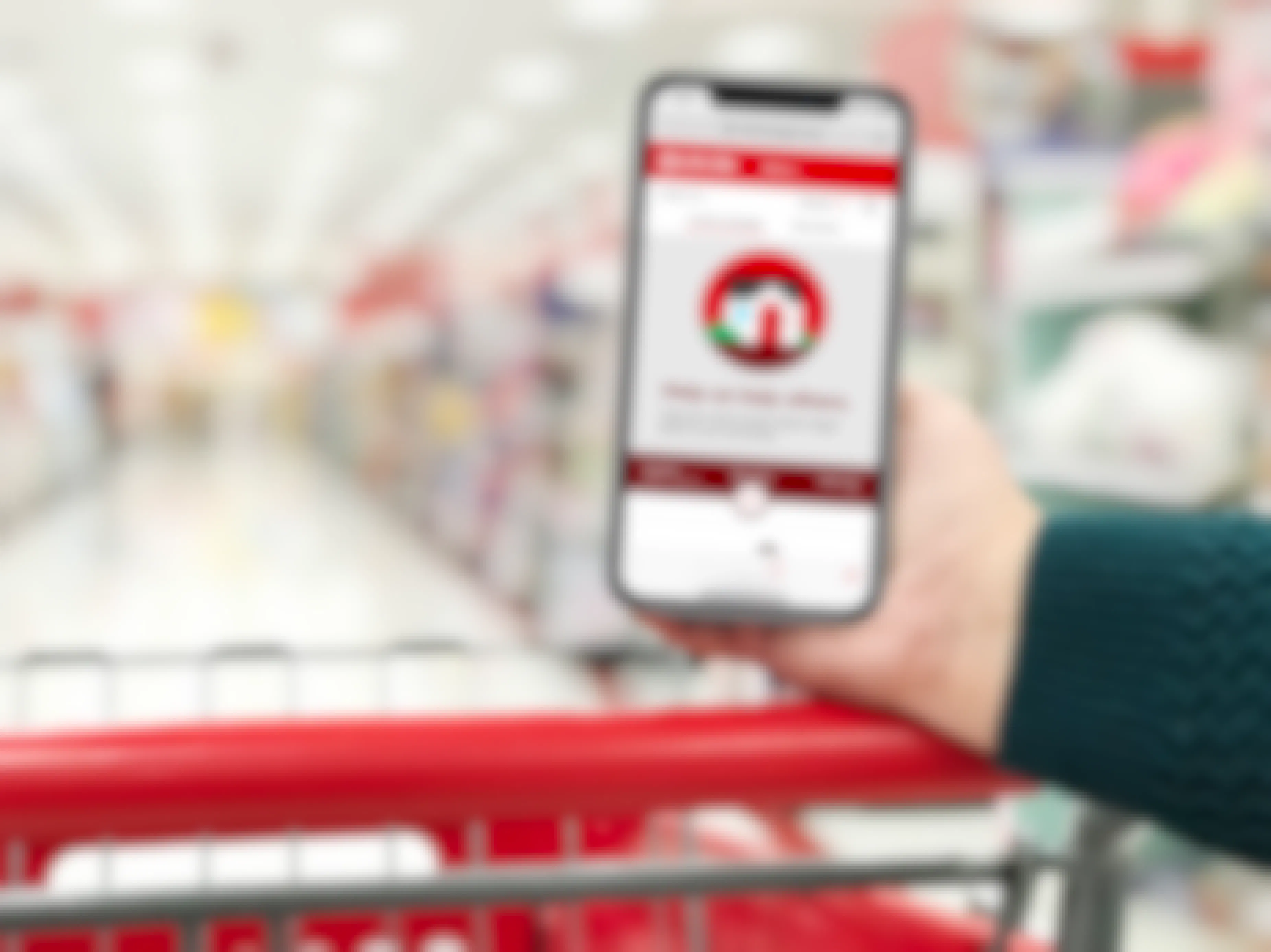 hand resting on a red shopping cart holding phone showing target circle app