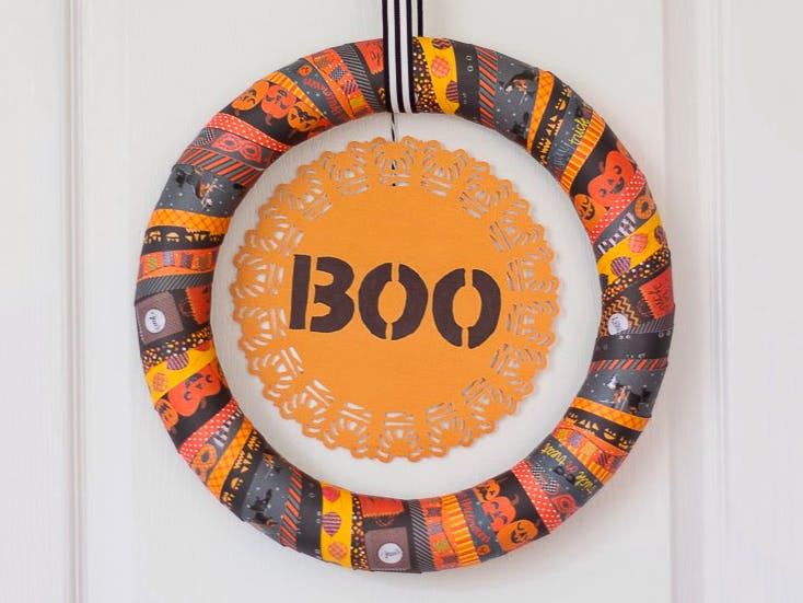 A Halloween washi tape wreath hanging on a door.