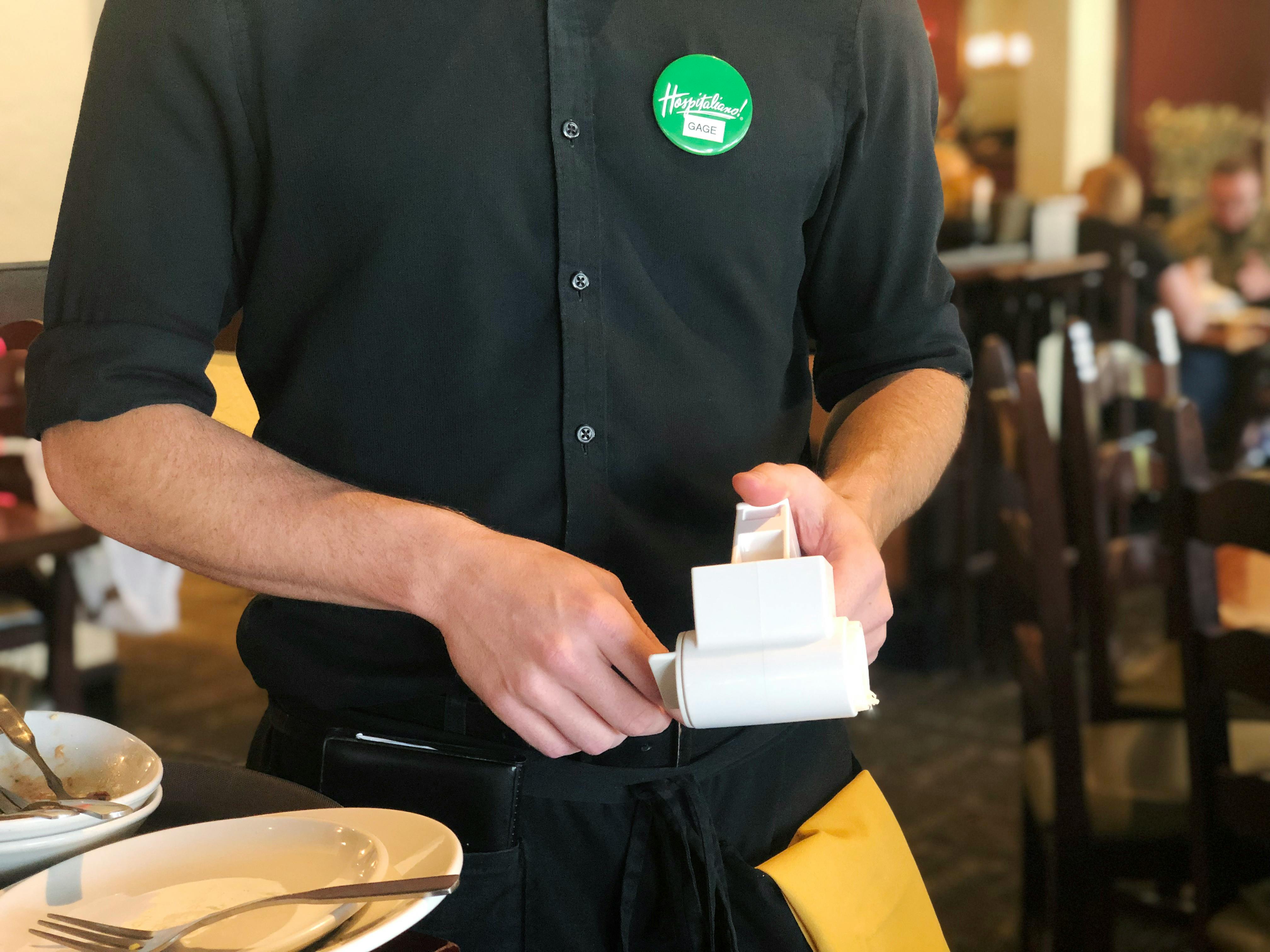 a server with a cheese grater in hand 