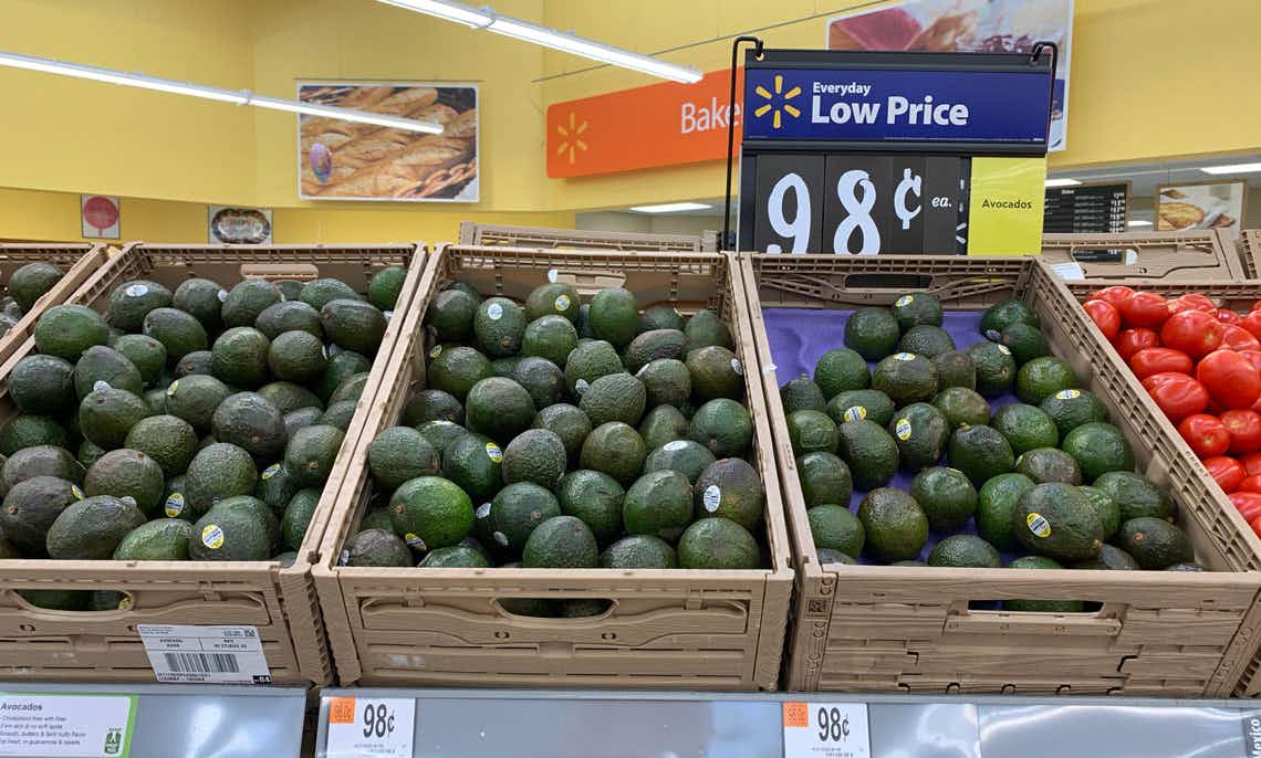 avocados in tan crates in front of a walmart everyday low price sign indicating $0.98