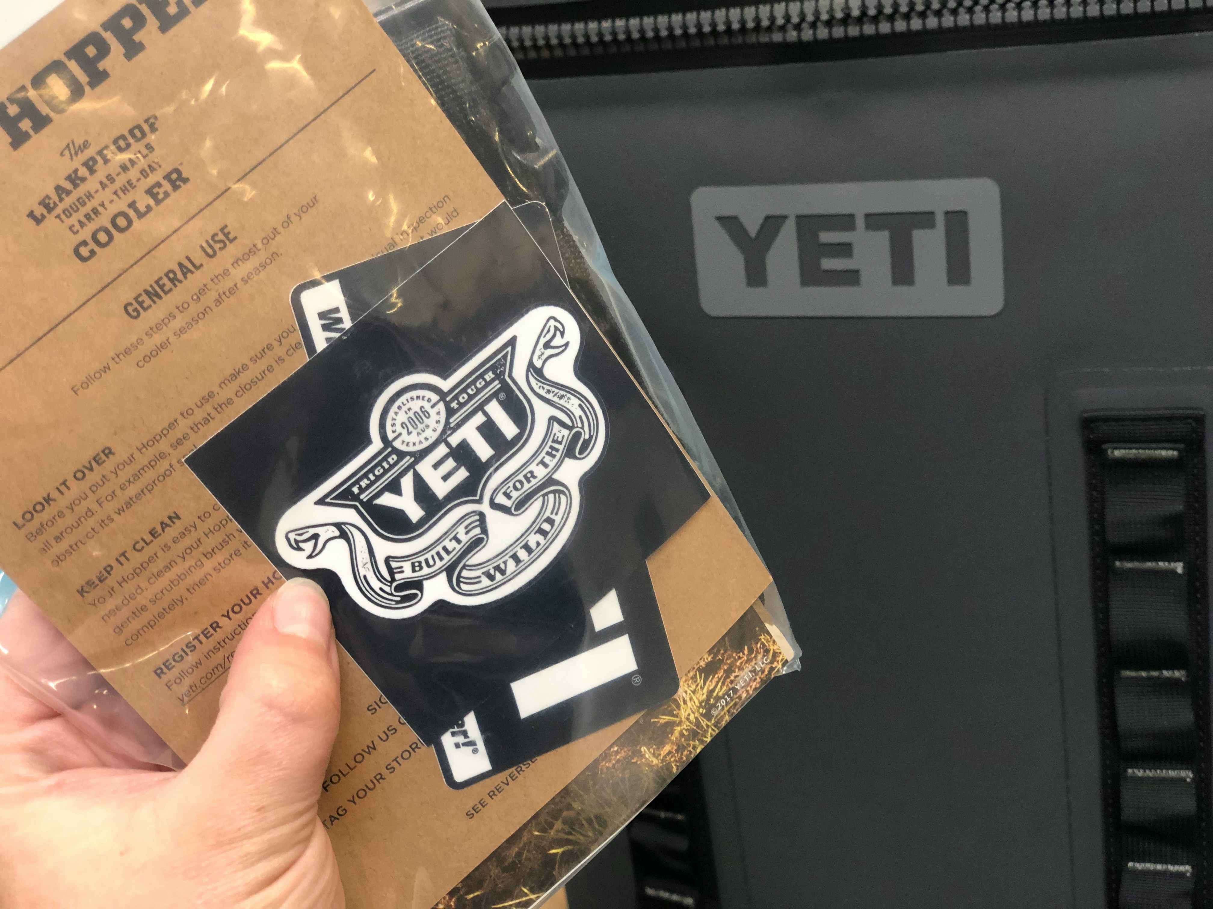 A person holding a clear bag with a YETI sticker inside.