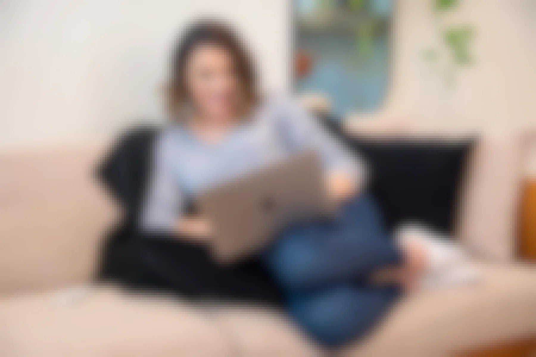 woman sitting on a couch on her laptop