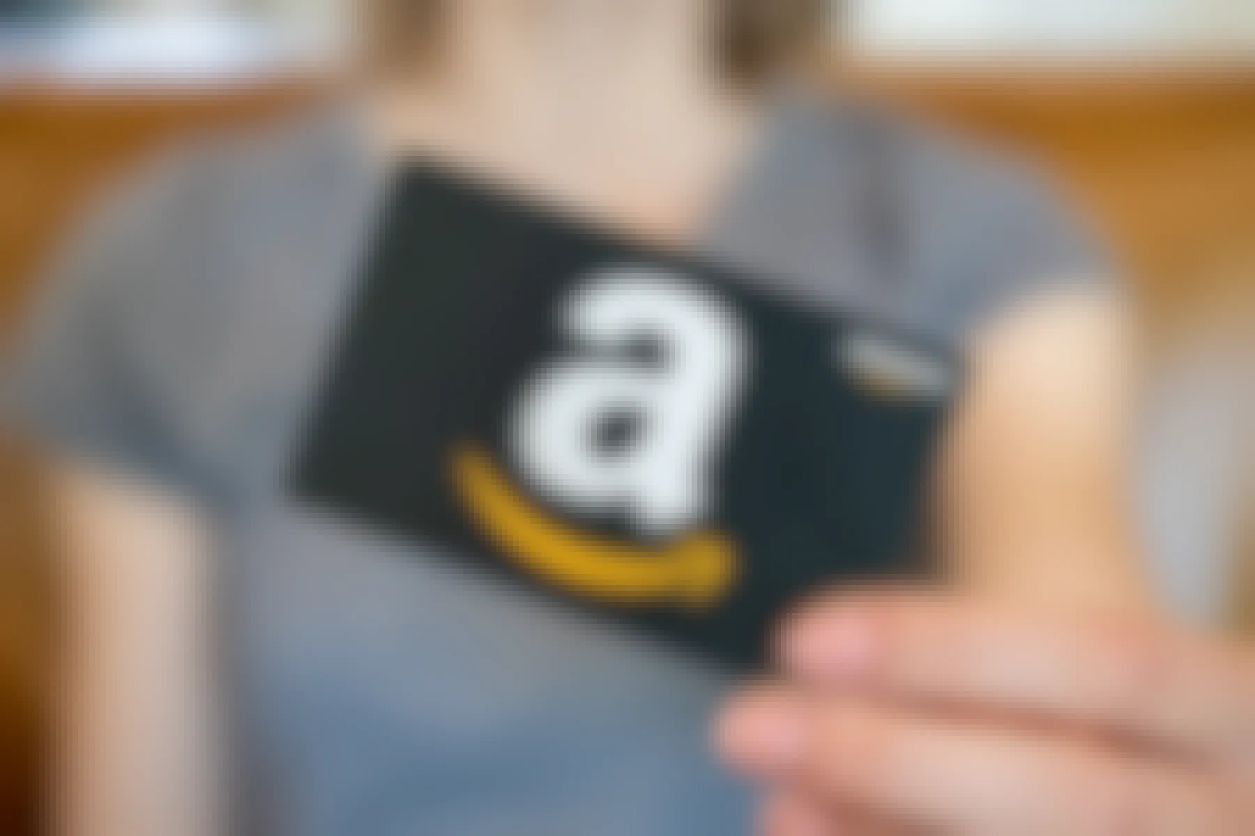 A woman holding an amazon gift card in front of her