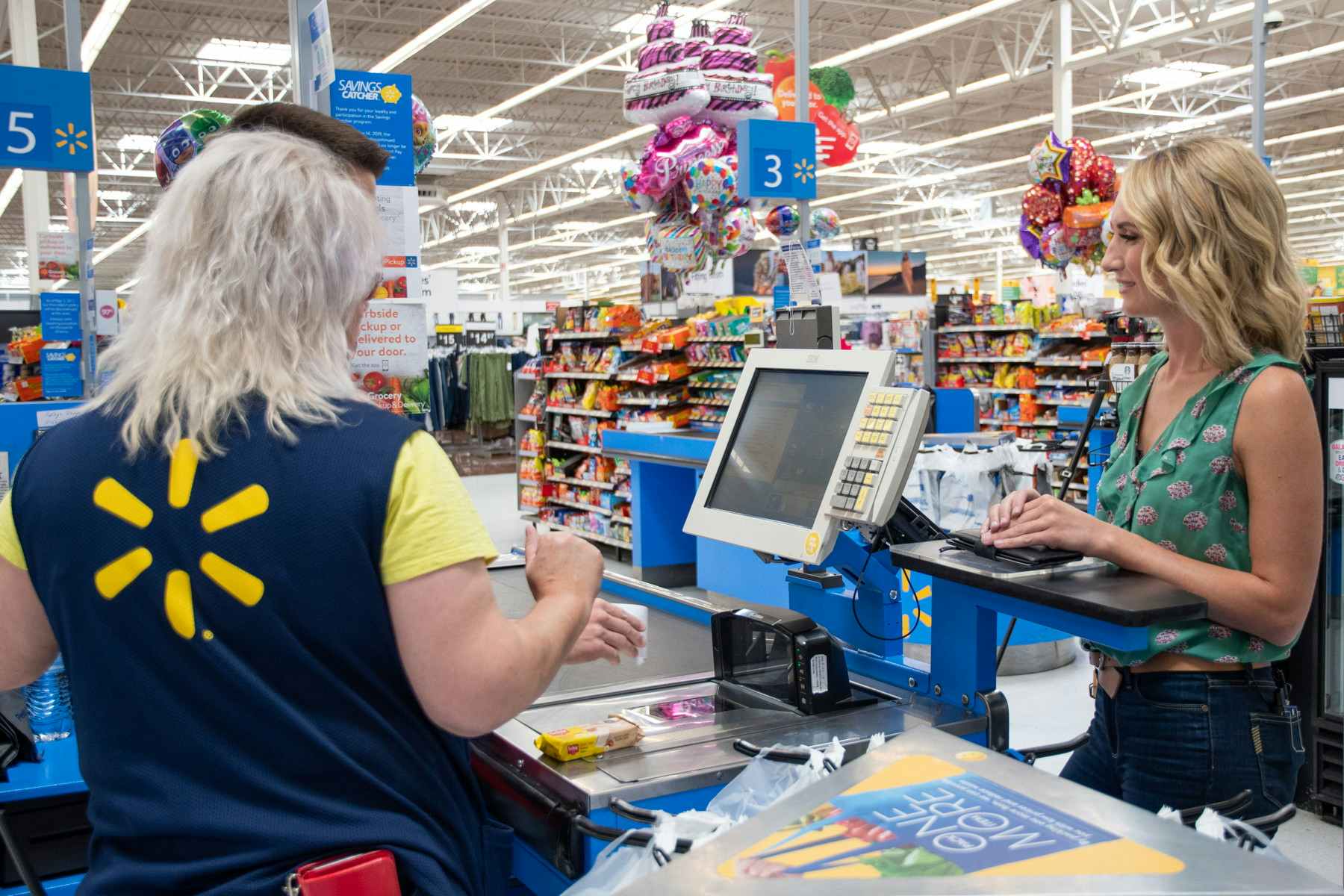 A woman at a Walmart checkout — a store that will be open on 4th of July