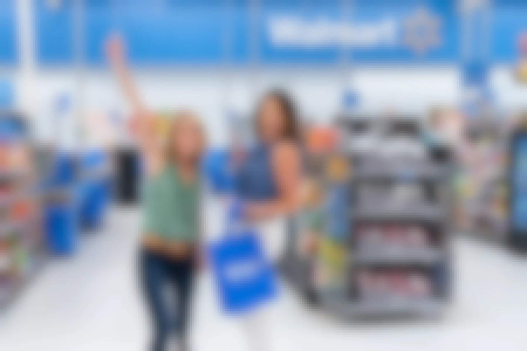 Two shoppers lifting their hands up to celebrate a successful shopping trip inside Walmart.