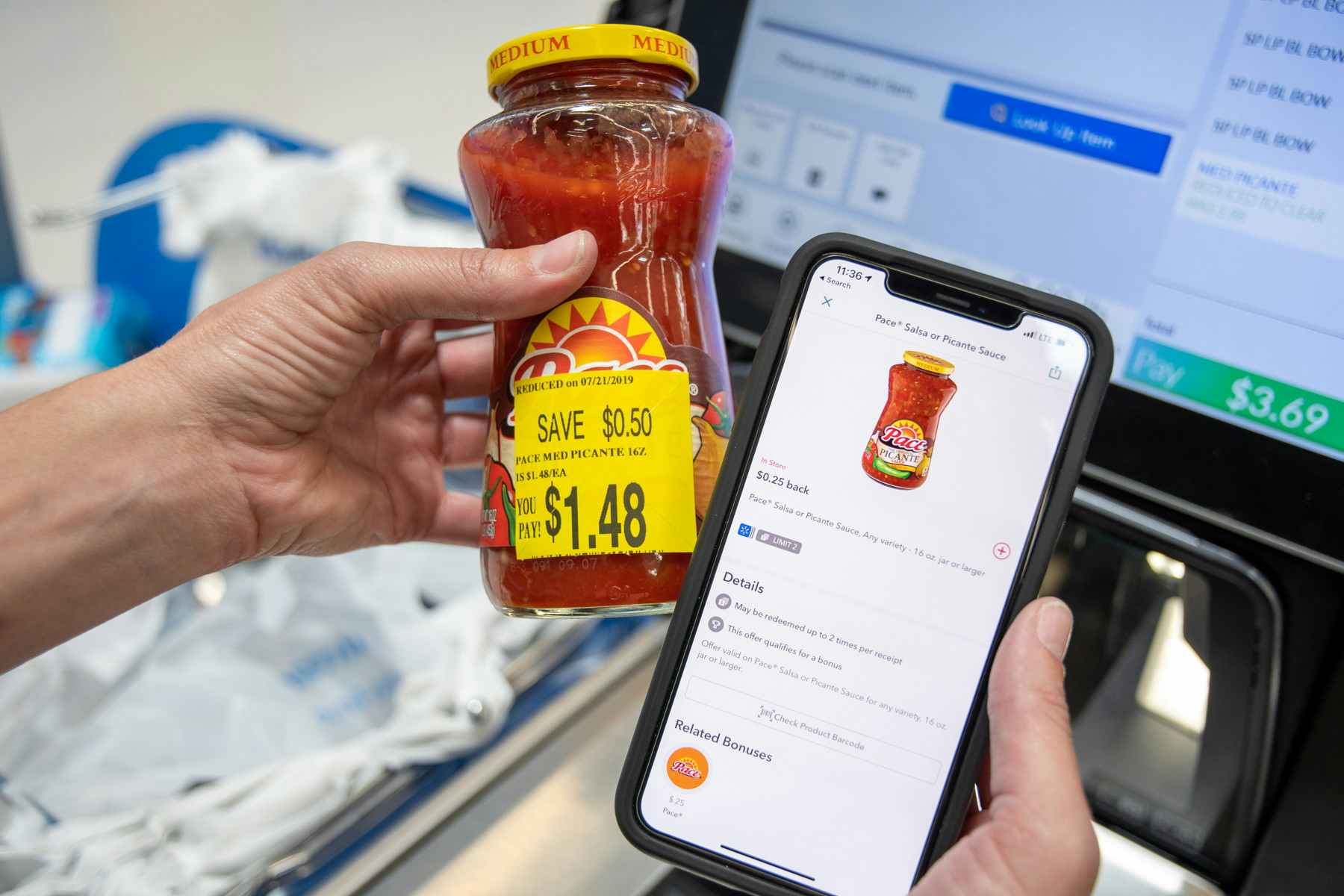 A person's hands, one holding a jar of Pace Medium Picante Salsa with a sticker showing the price as $1.48, and the other hand is holding up an iPhone with a rebate mobile app open showing the same product qualifying for $0.25 back.