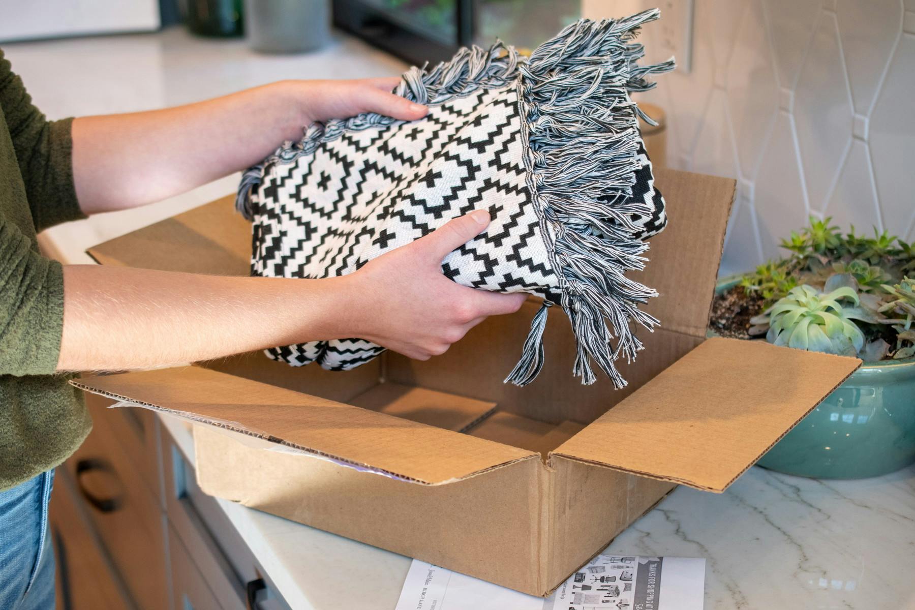 Person pulling a blanket out of a Wayfair box