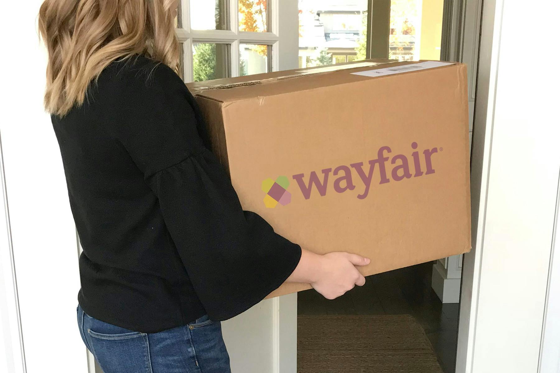 person carrying large wayfair delivery box inside