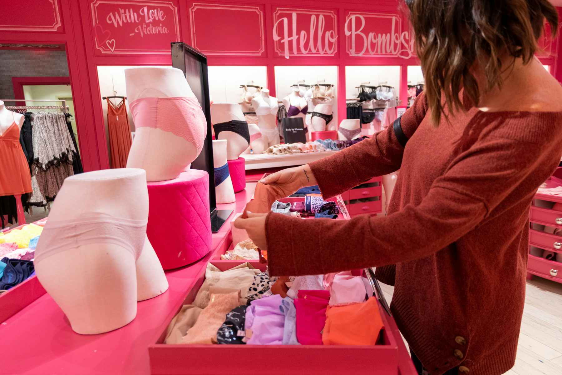 A woman looking through some panties on display at Victoria's Secret.