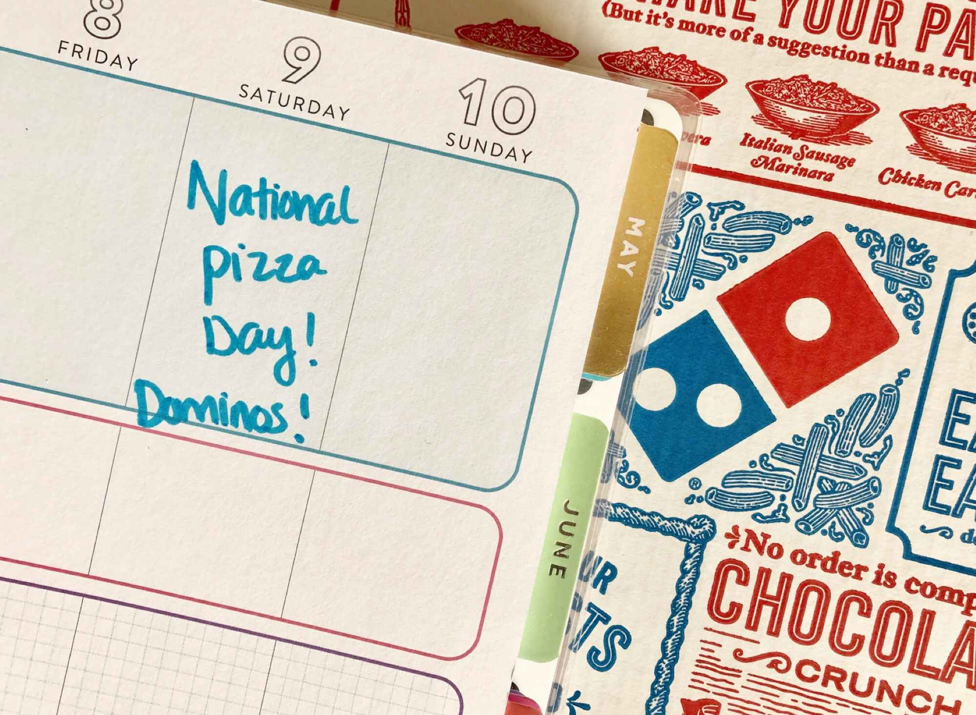 a calander with national pizza day in front of pizza 