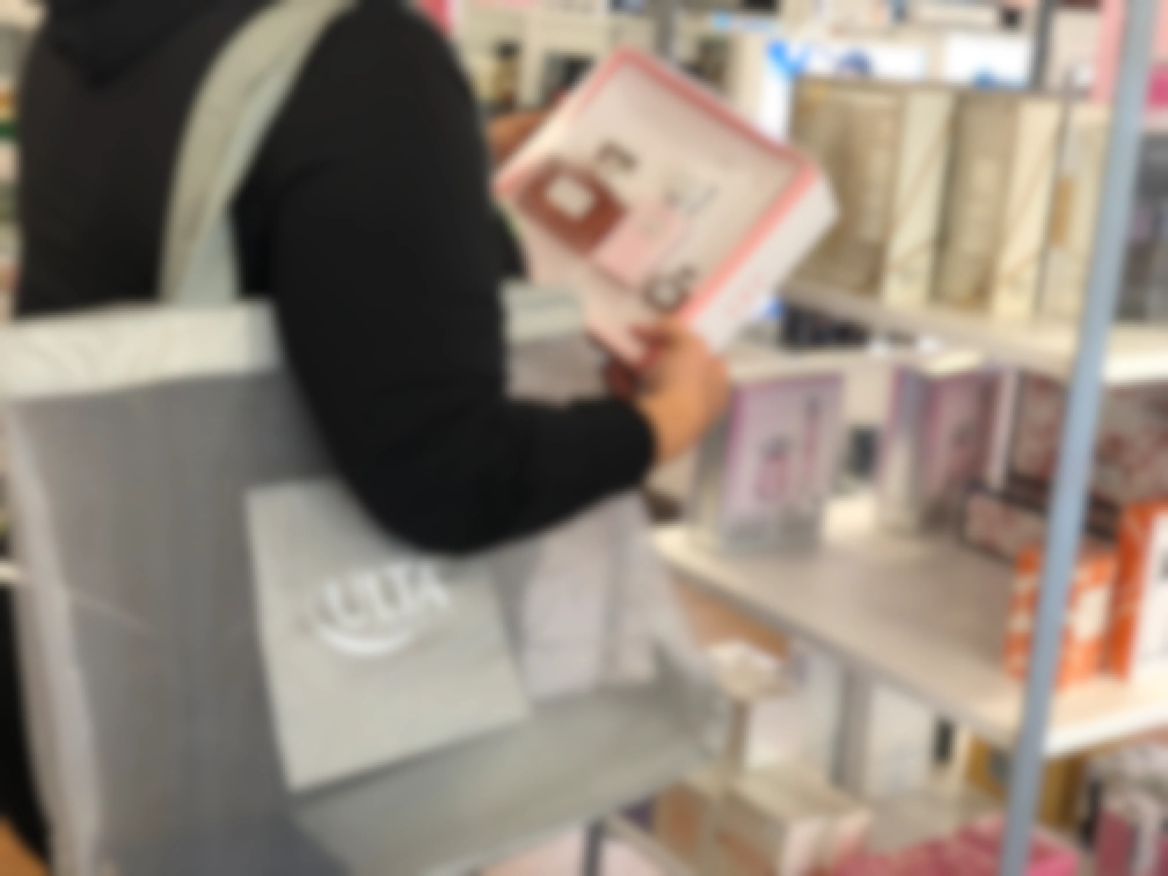 A person holding a fragrance gift box set inside an Ulta store
