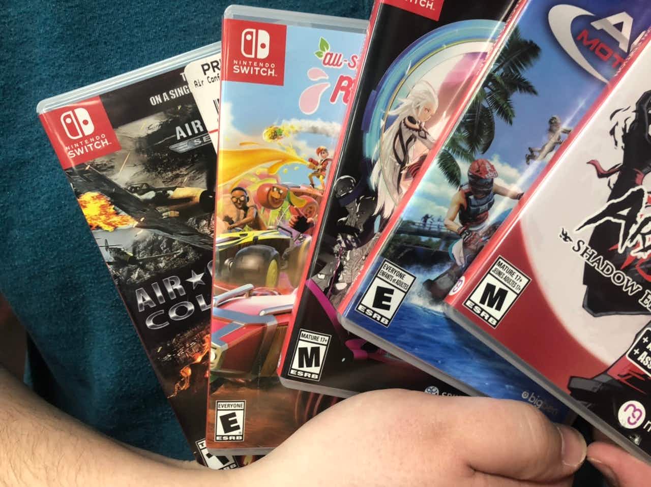 A man holds a stack of Nintendo games.