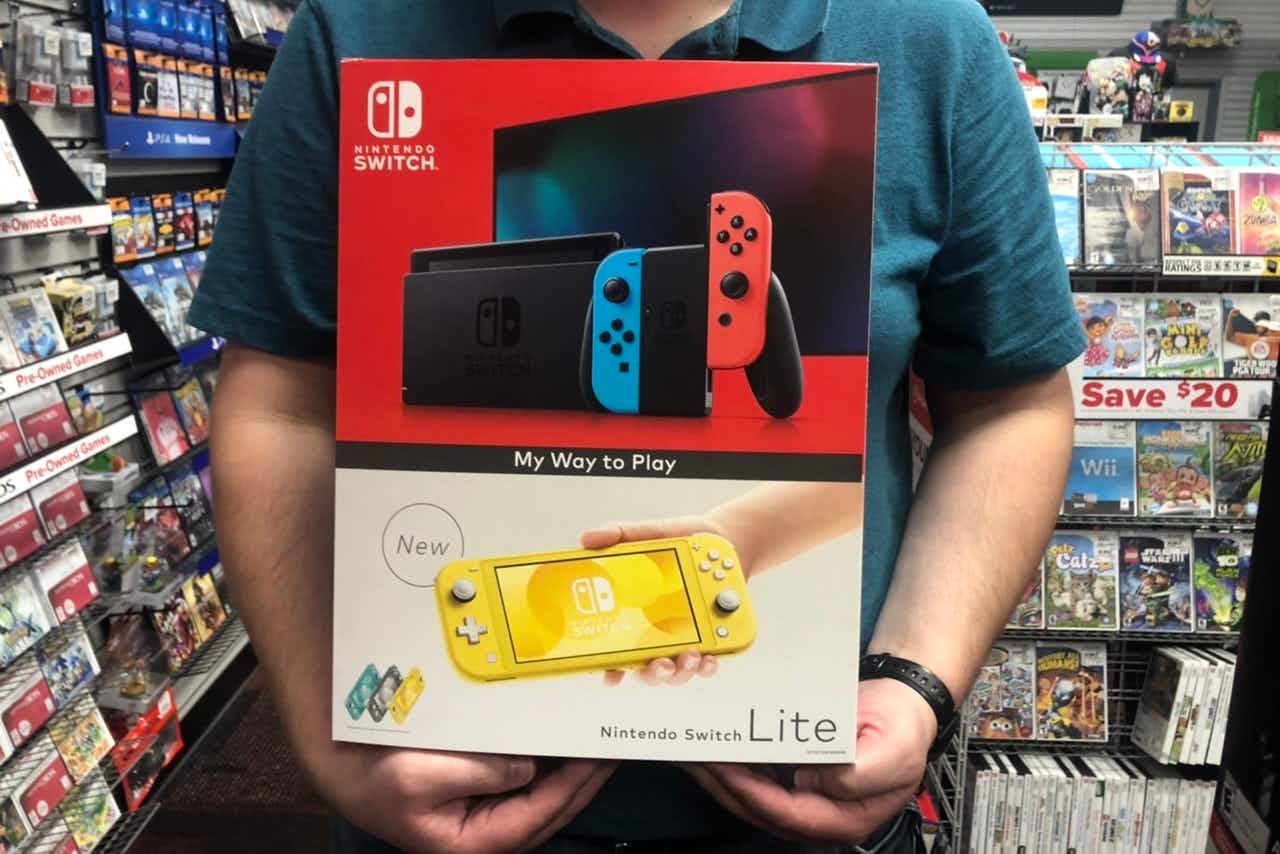 A man holds a box for Nintendo switch lite in GameStop