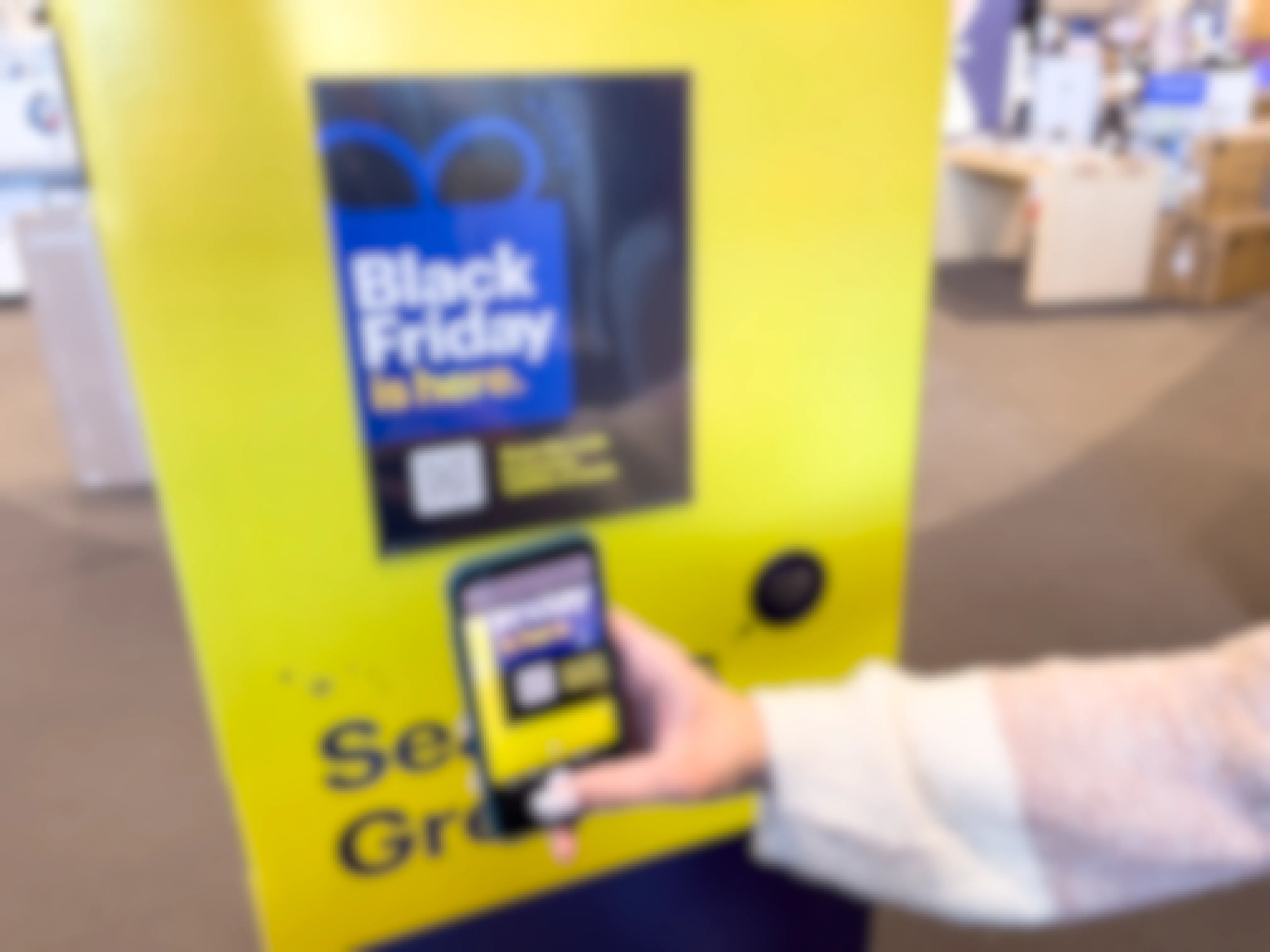 A person scanning the black friday ad QR code sign with a cell phone