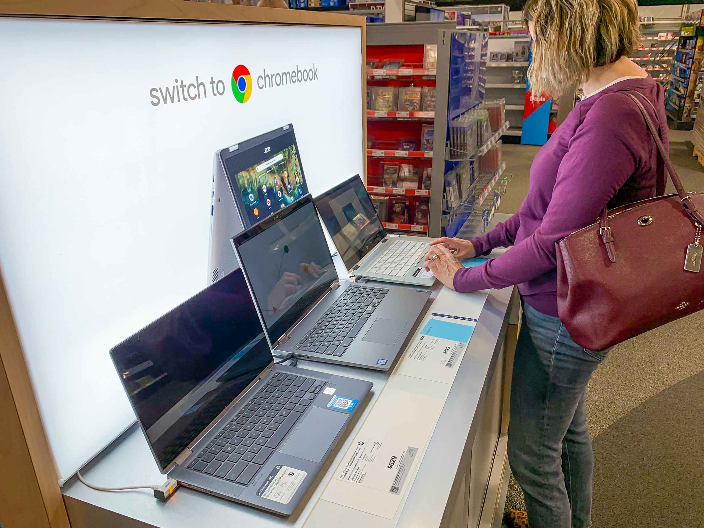 a woman looking down and using the touch pad on a Chromebook on display at Best Buy.
