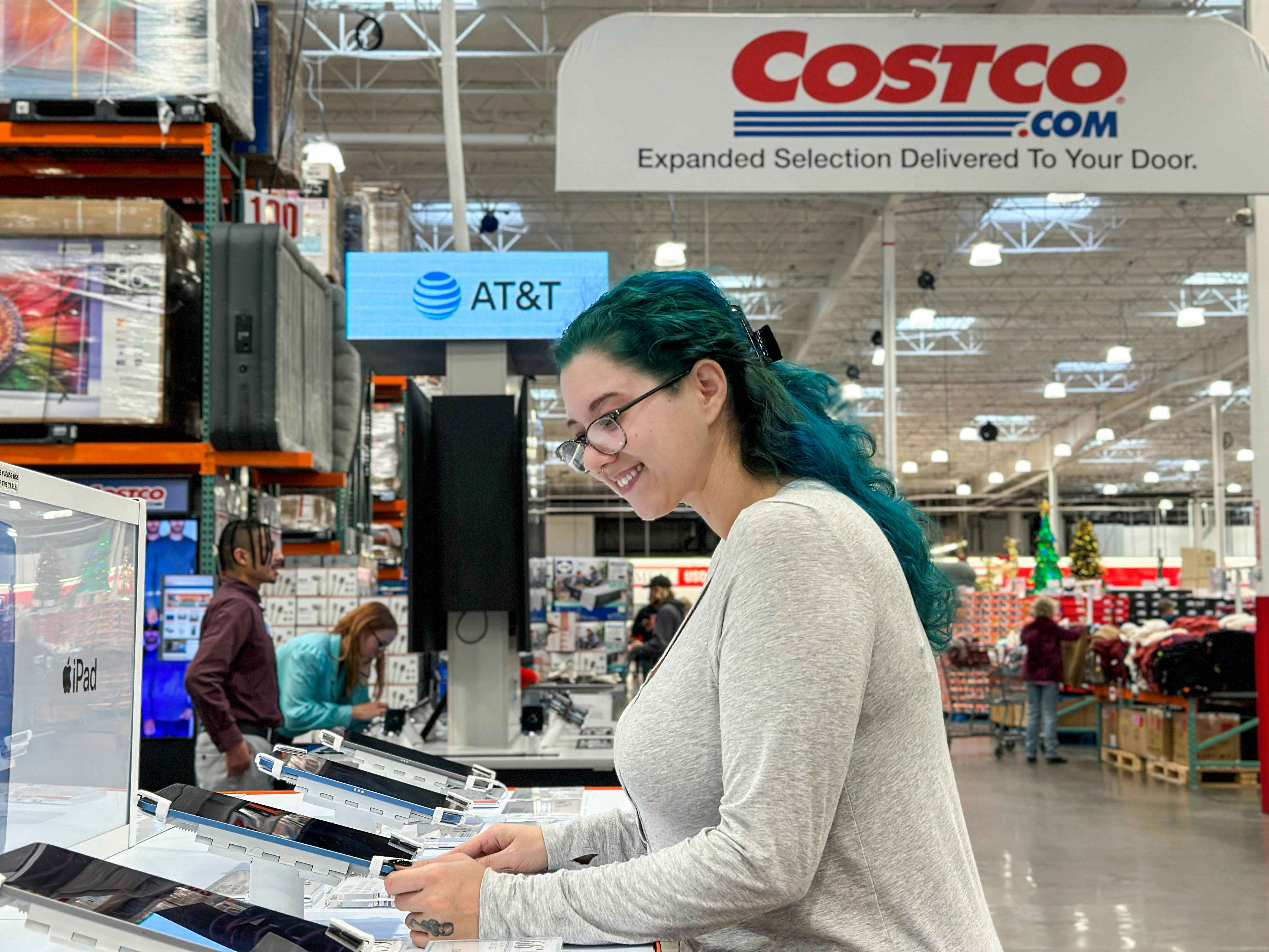 a woman looking at ipads in costco