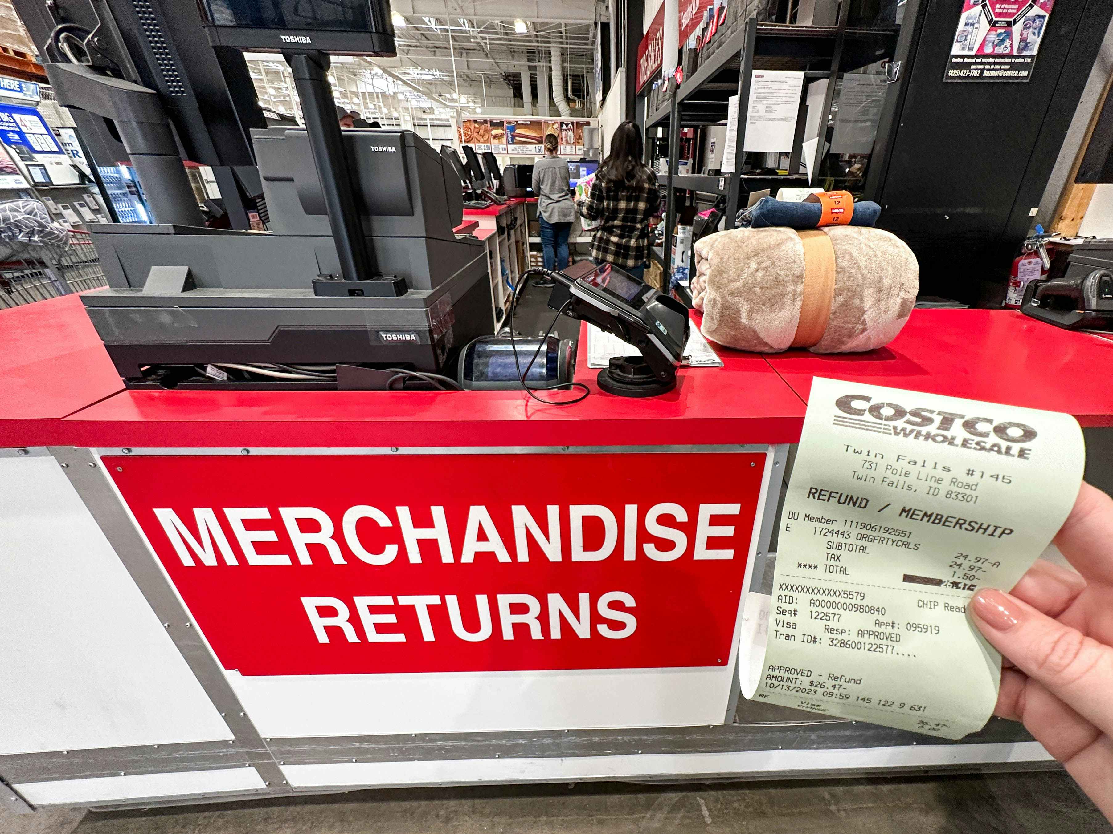 a receipt being held in front of return counter in costco 