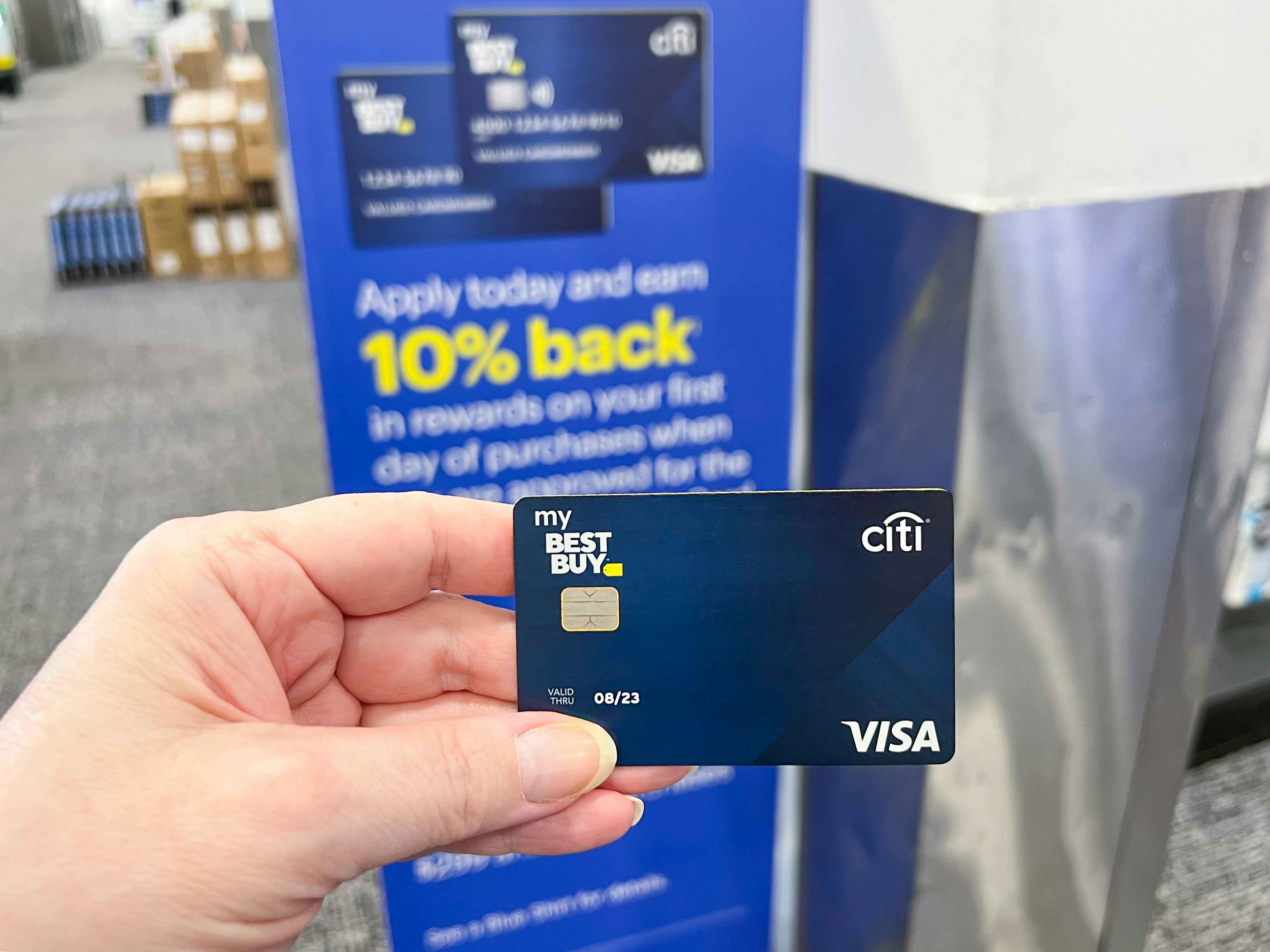 someone holding a my Best Buy credit card inside a Best Buy store