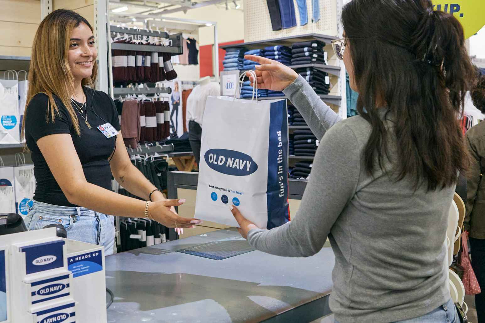 old navy cashier handing shopper bag at checkout