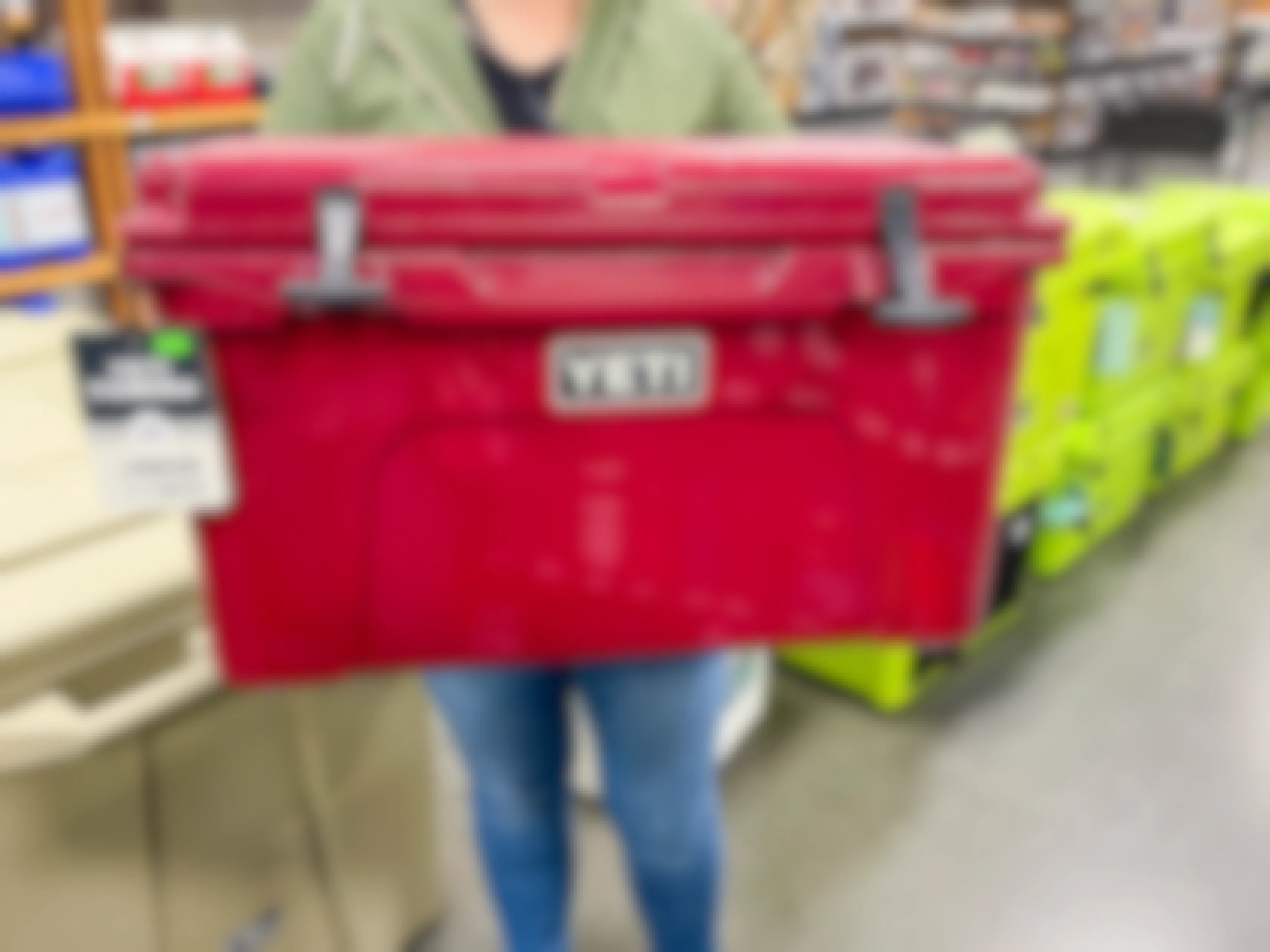 Person holding a large YETI cooler inside a store.