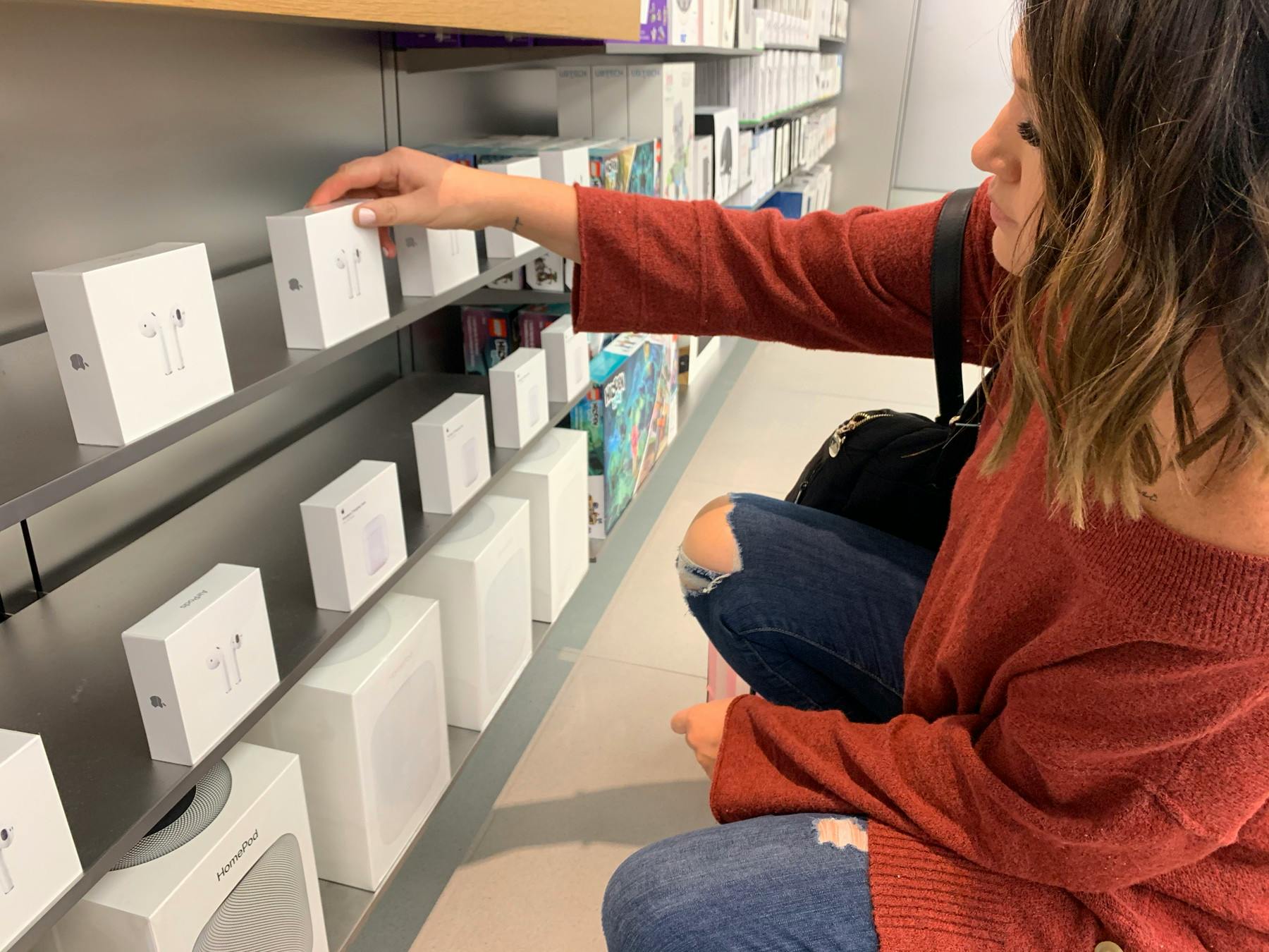 Woman looking at AirPods in the Apple Store.