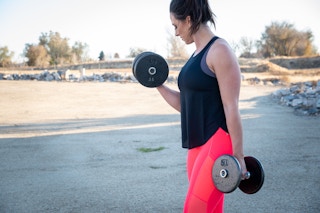 woman working out with dumbells in fabletics