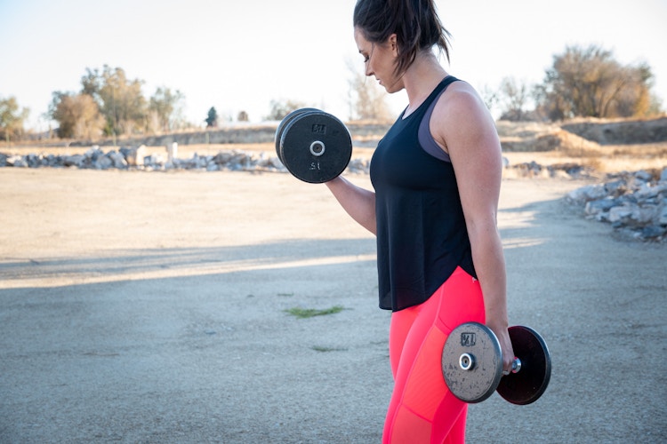 woman working out with dumbells in fabletics