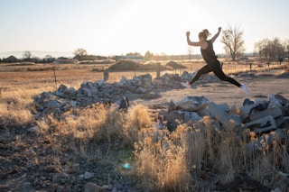 woman in black workout wear fabletics jumping