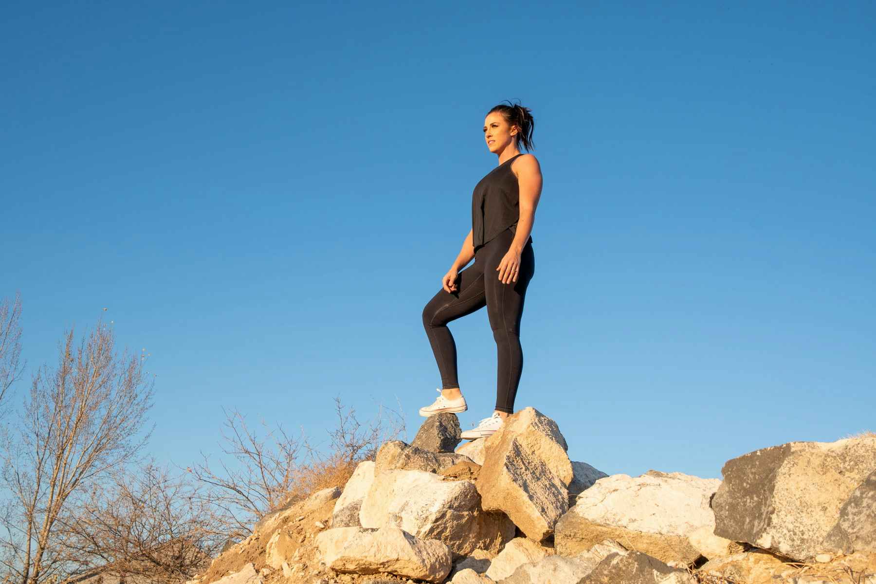 woman standing on rocks wearing fabletics outfit
