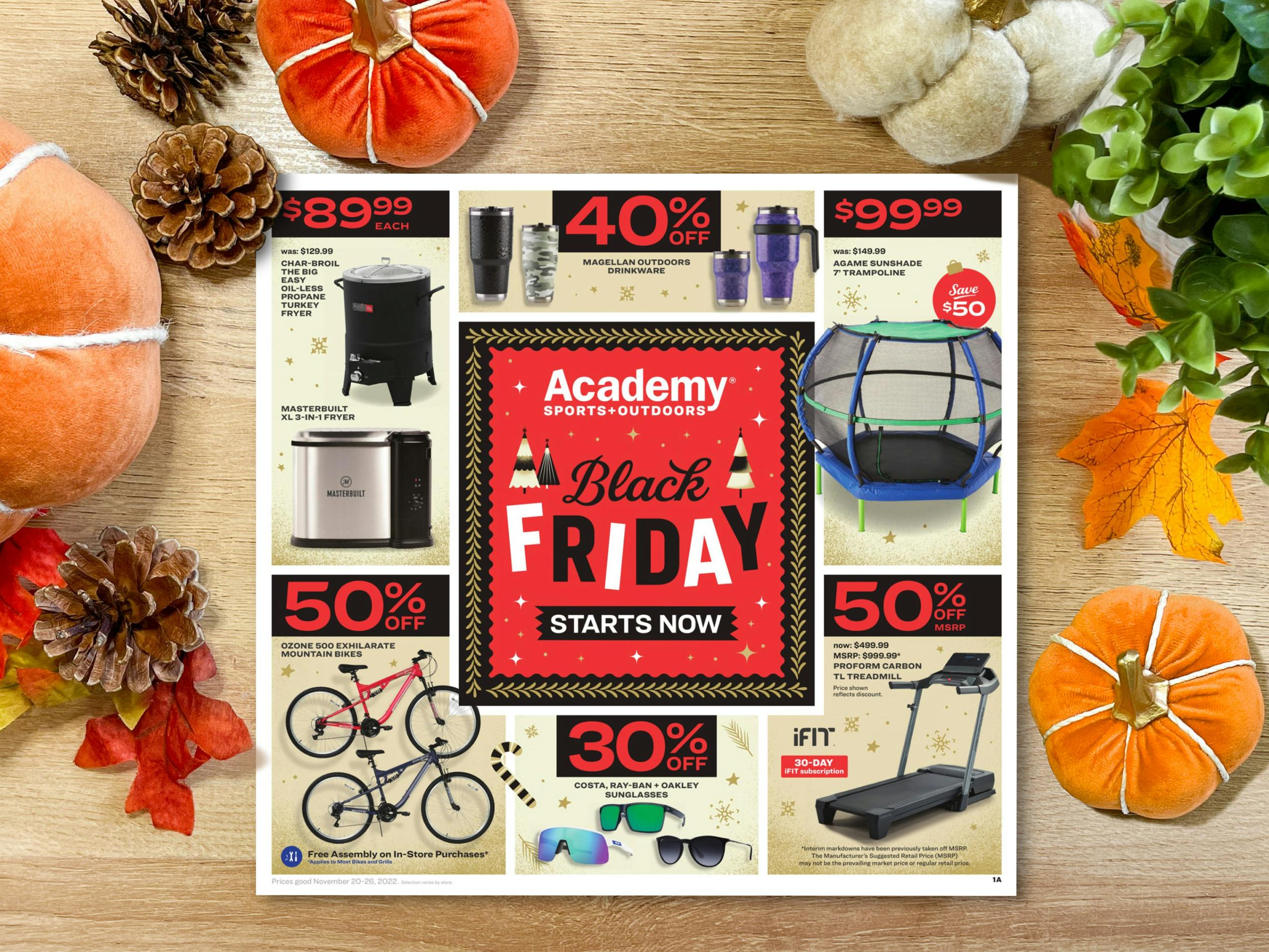 The Academy Sports 2022 Black Friday advertisement on a table with autumn decor