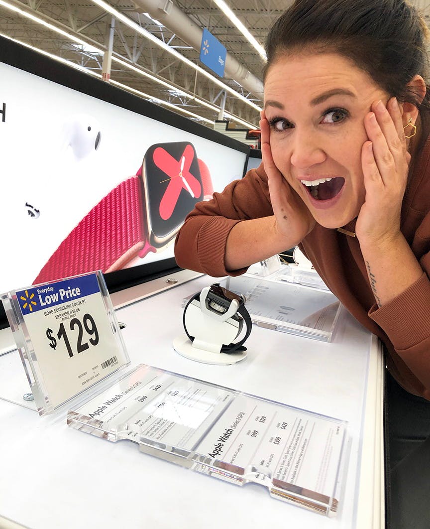 A woman making an excited face next to an apple watch with a price tag of $129.