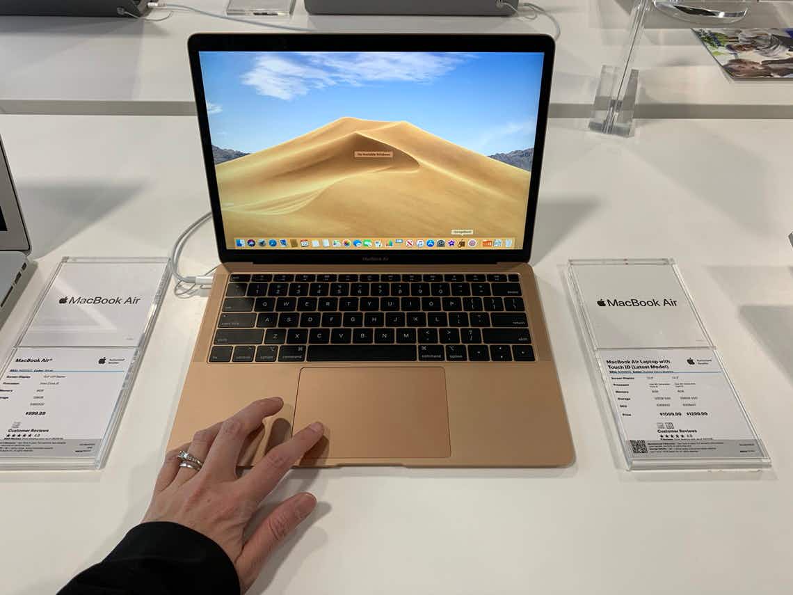Someone testing out a Macbook on display in a store