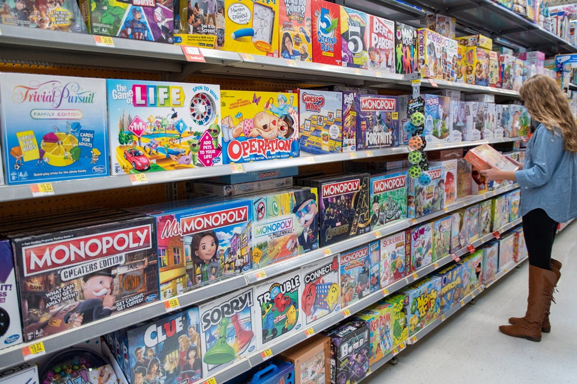 A woman looking at board games in the board game aisle at Walmart. 