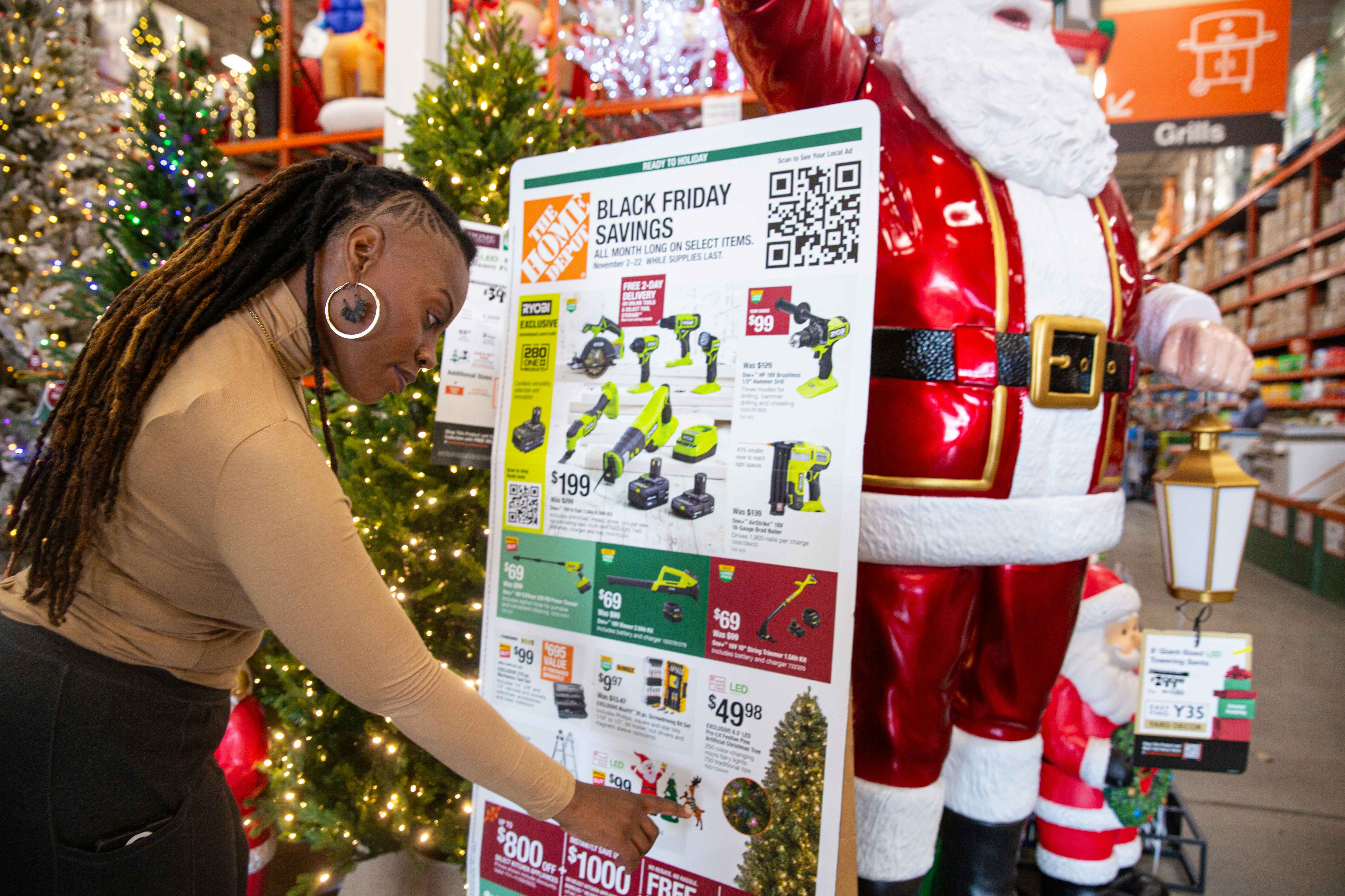 a woman looking at the black friday ad display at Home Depot